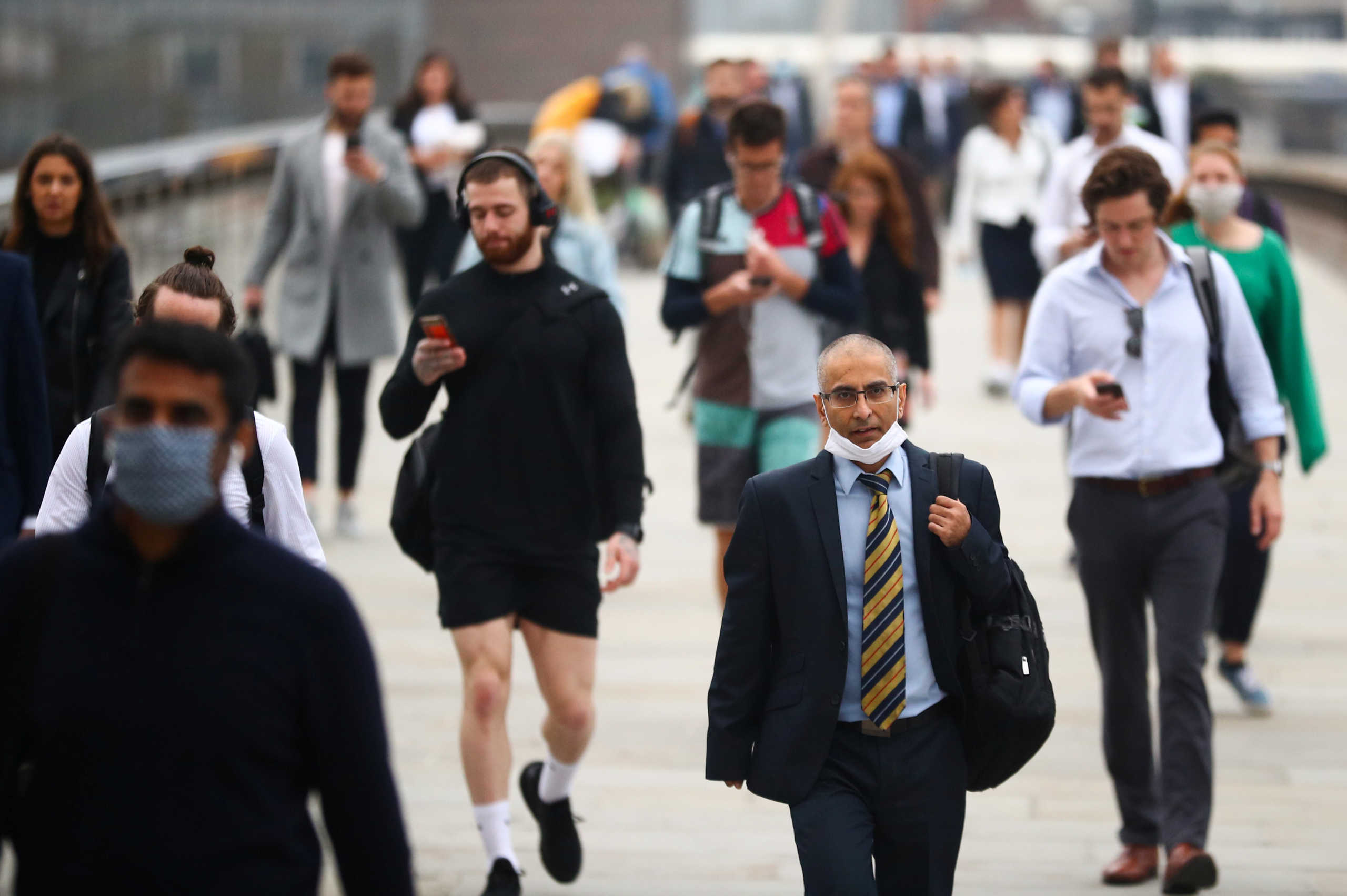 Commuters walk across the London Bridge during the morning rush hour, amid an outbreak of the coronavirus disease (COVID-19), in London, Britain September 21, 2020. REUTERS