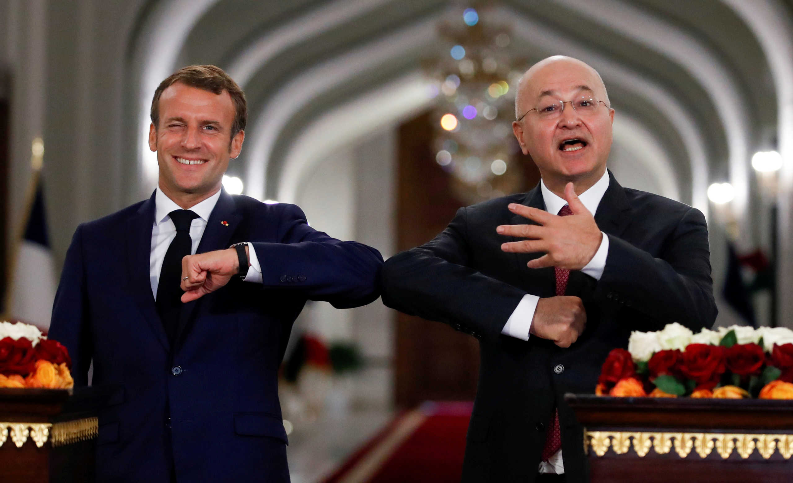 French President Emmanuel Macron and Iraq's President Barham Salihat greet each other with an elbow bump as they attend a news conference, in Baghdad, Iraq September 2, 2020. REUTERS