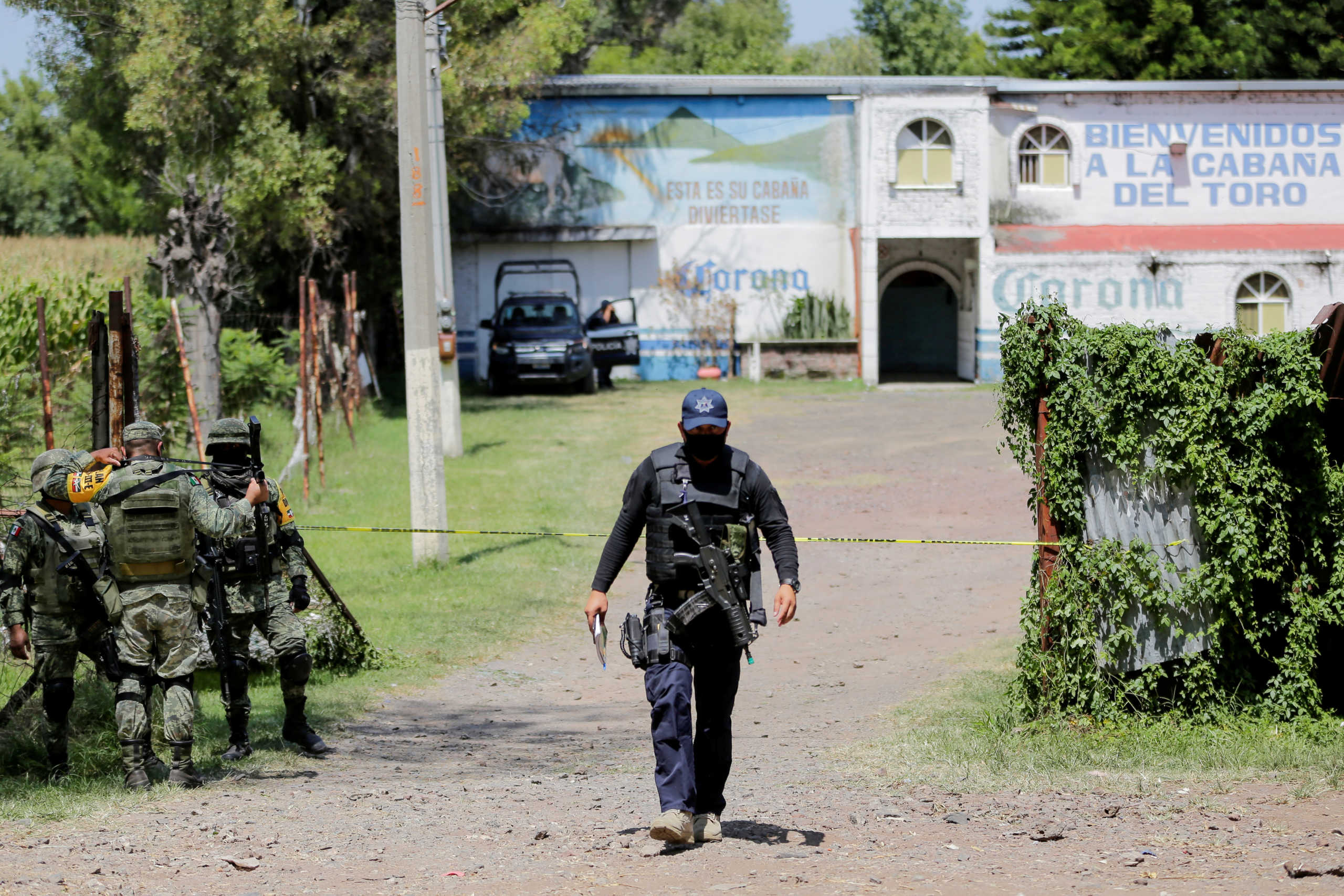 A police officer and soldiers keep watch outside a bar after a massacre in a bar left eleven people dead in Jaral del Progreso in Guanajuato state, Mexico, September 27, 2020. REUTERS