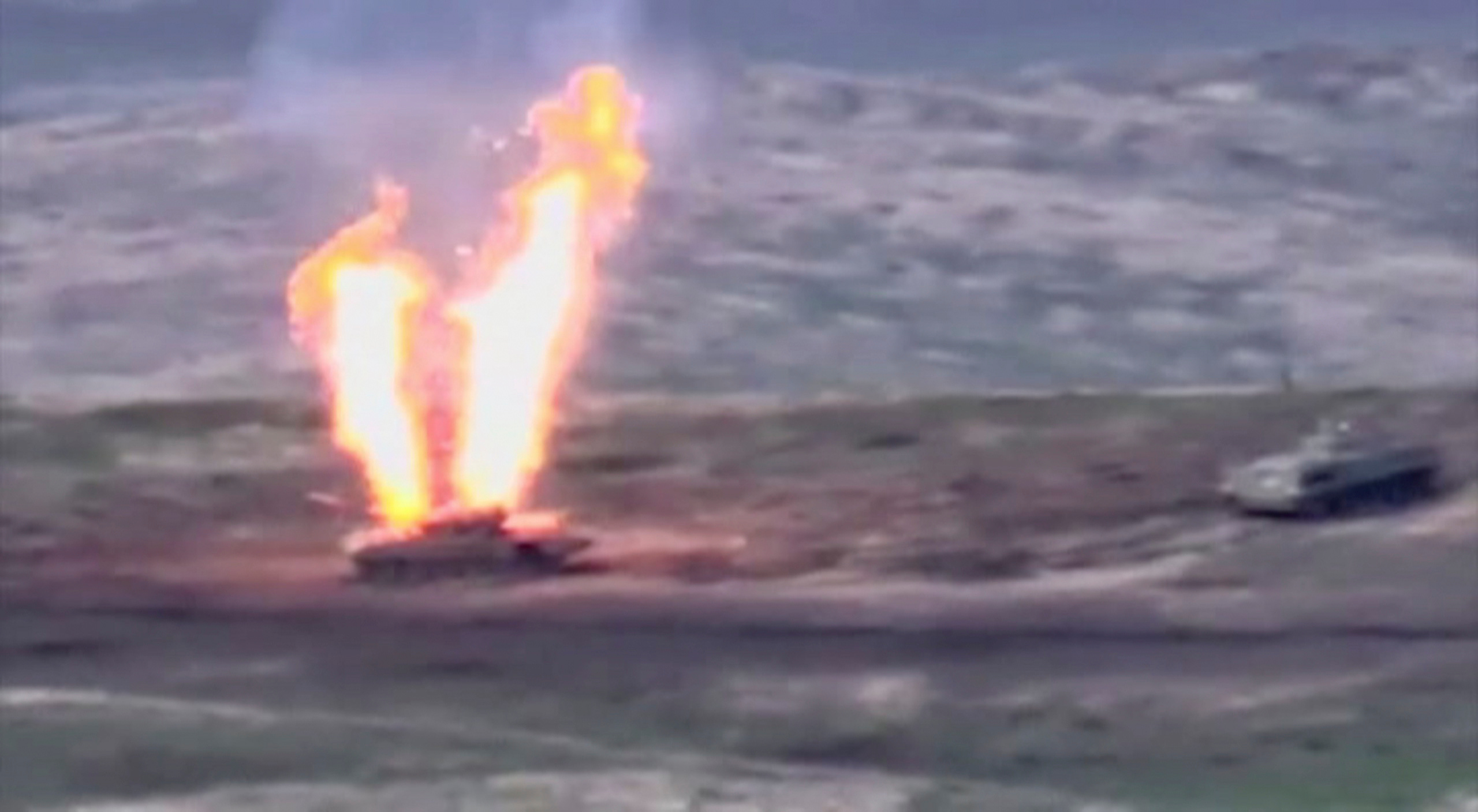 A still image from a video released by the Armenian Defence Ministry shows what is said to be Azerbaijani armoured vehicles, one of which is destroyed by Armenian armed forces in the breakaway region of Nagorno-Karabakh, in this still image from footage released September 27, 2020. Defence Ministry of Armenia
