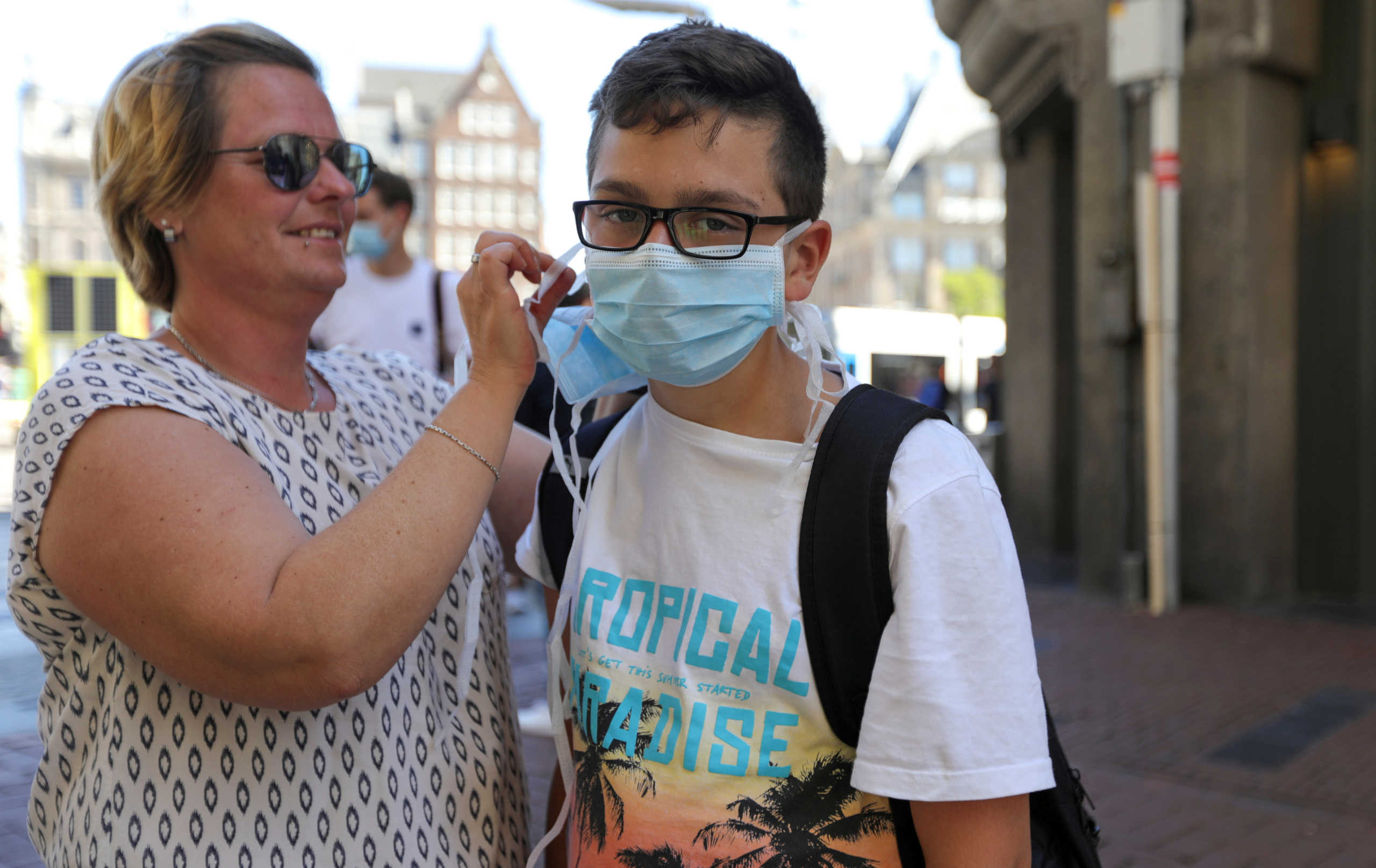FILE PHOTO: A mother puts a mask on her son at the busy street of Amsterdam, during the coronavirus disease (COVID-19) outbreak, Netherlands August 5, 2020. REUTERS