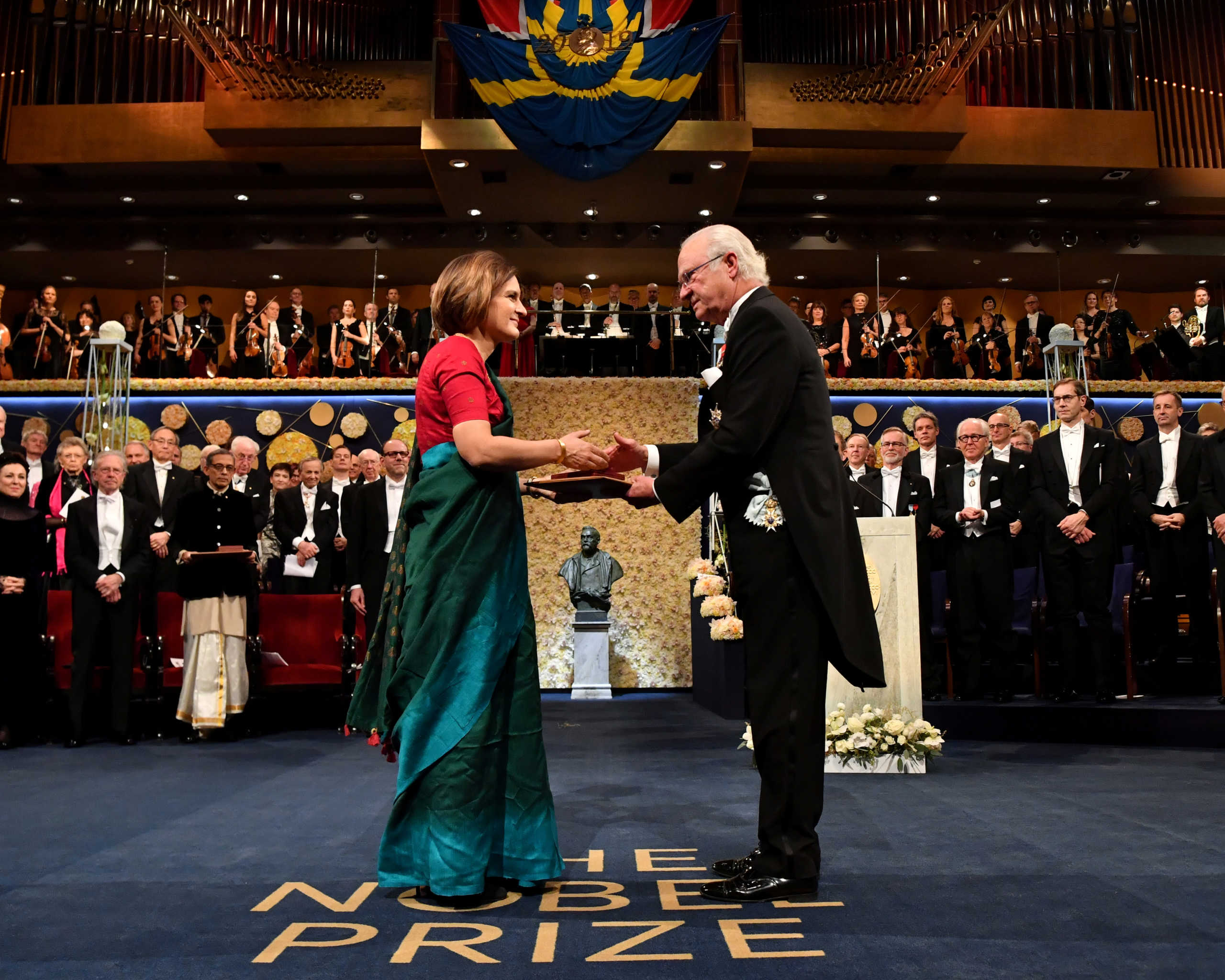 FILE PHOTO: French economist Esther Duflo shakes hands with Sweden's King Carl Gustaf as she receives the Sveriges Riksbank Prize in Economic Sciences in Memory of Alfred Nobel during the Nobel Prize award ceremony at the Stockholm Concert Hall in Stockholm, Sweden December 10, 2019.   TT News Agency