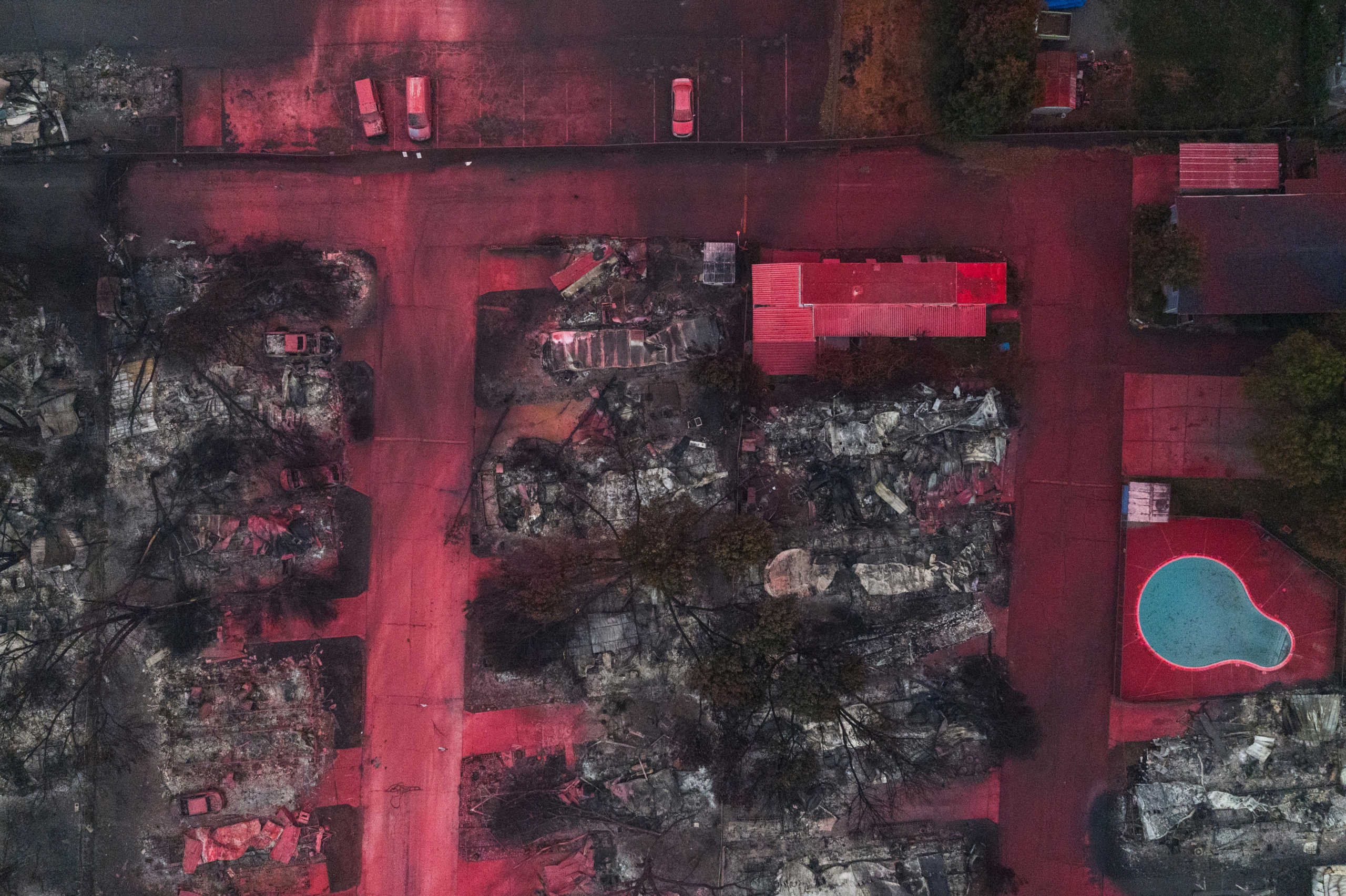 Red fire retardant blankets burned residences, vehicles and a swimming pool in the aftermath of the Almeda fire in Talent, Oregon, U.S., September 13, 2020. Picture taken with a drone.  REUTERS