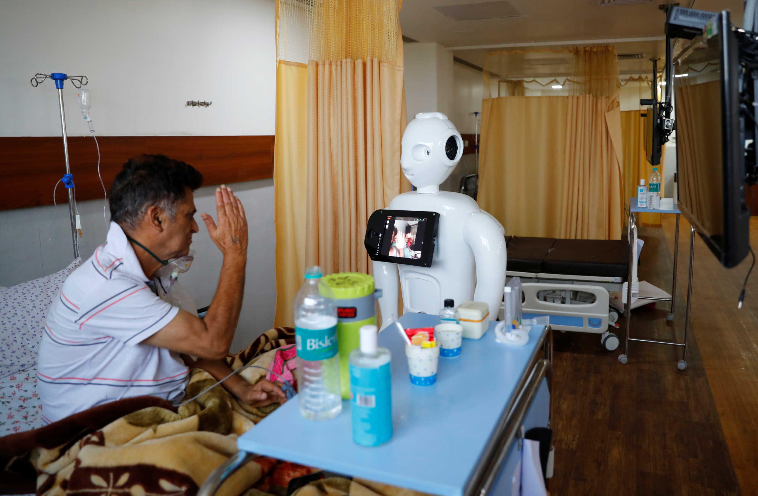 A patient suffering from the coronavirus disease (COVID-19) speaks to his family members, using a robot named 'Mitra' at the Intensive Care Unit (ICU) of the Yatharth Super Speciality Hospital in Noida, on the outskirts of New Delhi, India, September 15, 2020. Picture taken September 15, 2020. REUTERS
