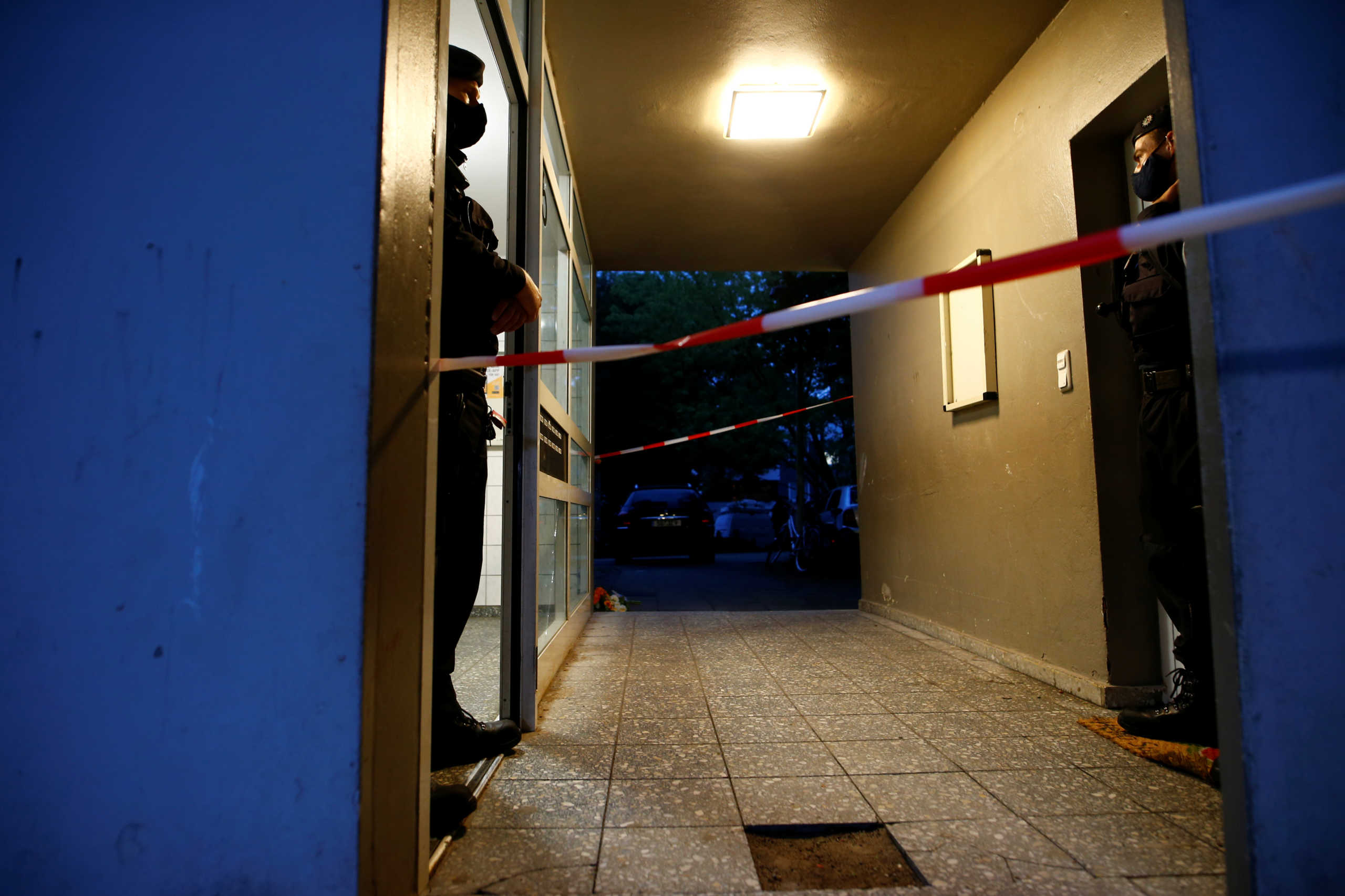 Police officers stand guard at the entrance of a residential building where the bodies of five children were found in the western town of Solingen, Germany, September 3, 2020. REUTERS
