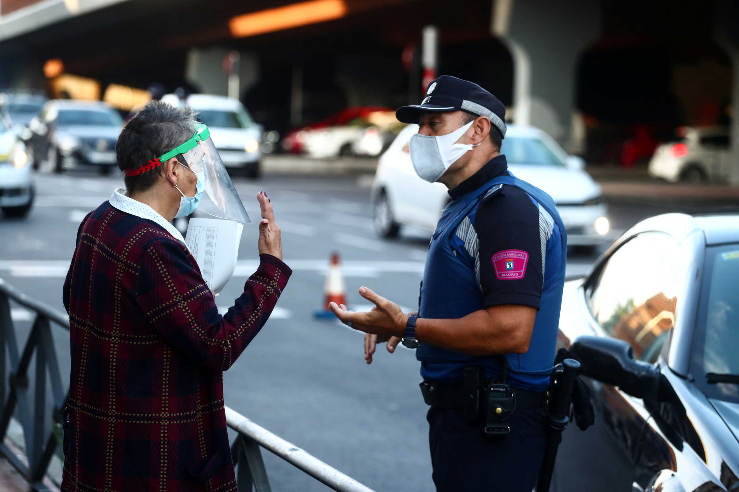A local police officer speaks with a woman in the Vallecas neighbourhood during the first day of a partial lockdown between and within areas in six districts amid the outbreak of the coronavirus disease (COVID-19) in Madrid, Spain, September 21, 2020. REUTERS