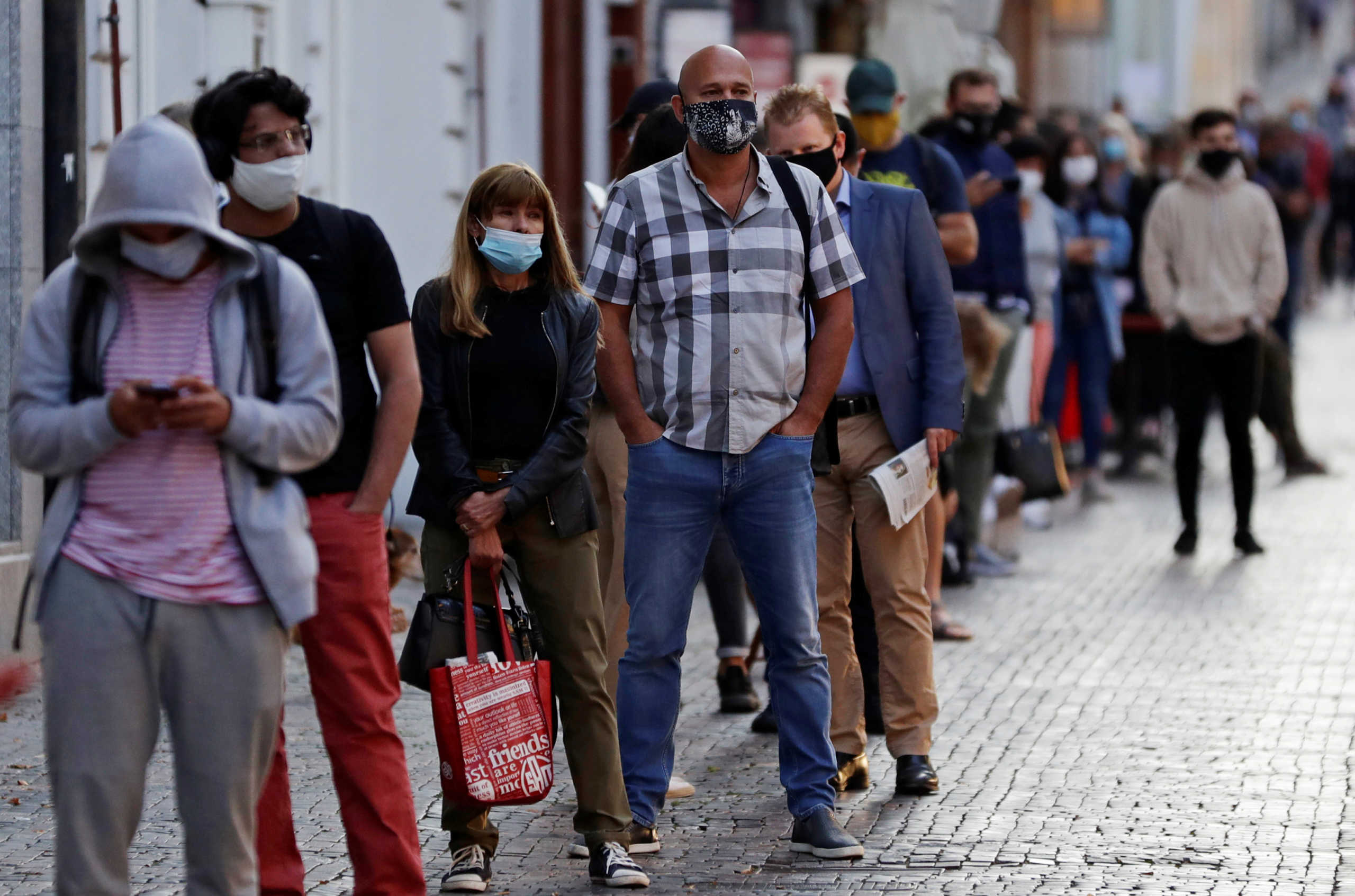 People wait in a line to get tested for the coronavirus disease (COVID-19) before a sampling station opens at Wenceslas Square in Prague, Czech Republic, September 16, 2020.     REUTERS