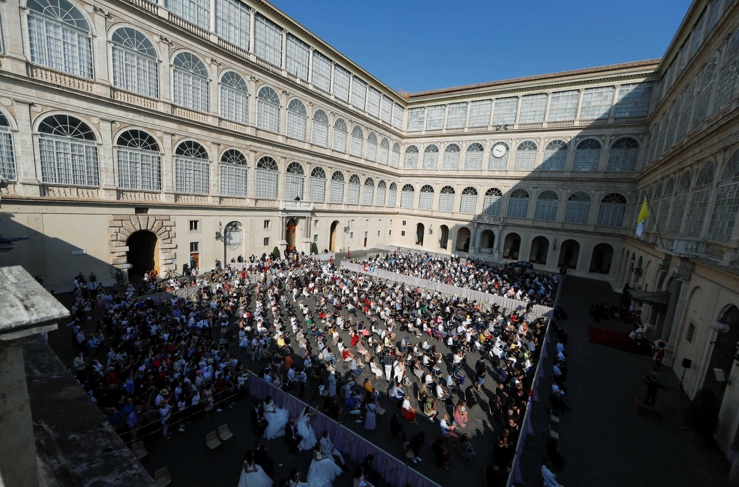 People sit at the San Damaso courtyard for the weekly general audience at the Vatican, September 16, 2020. REUTERS