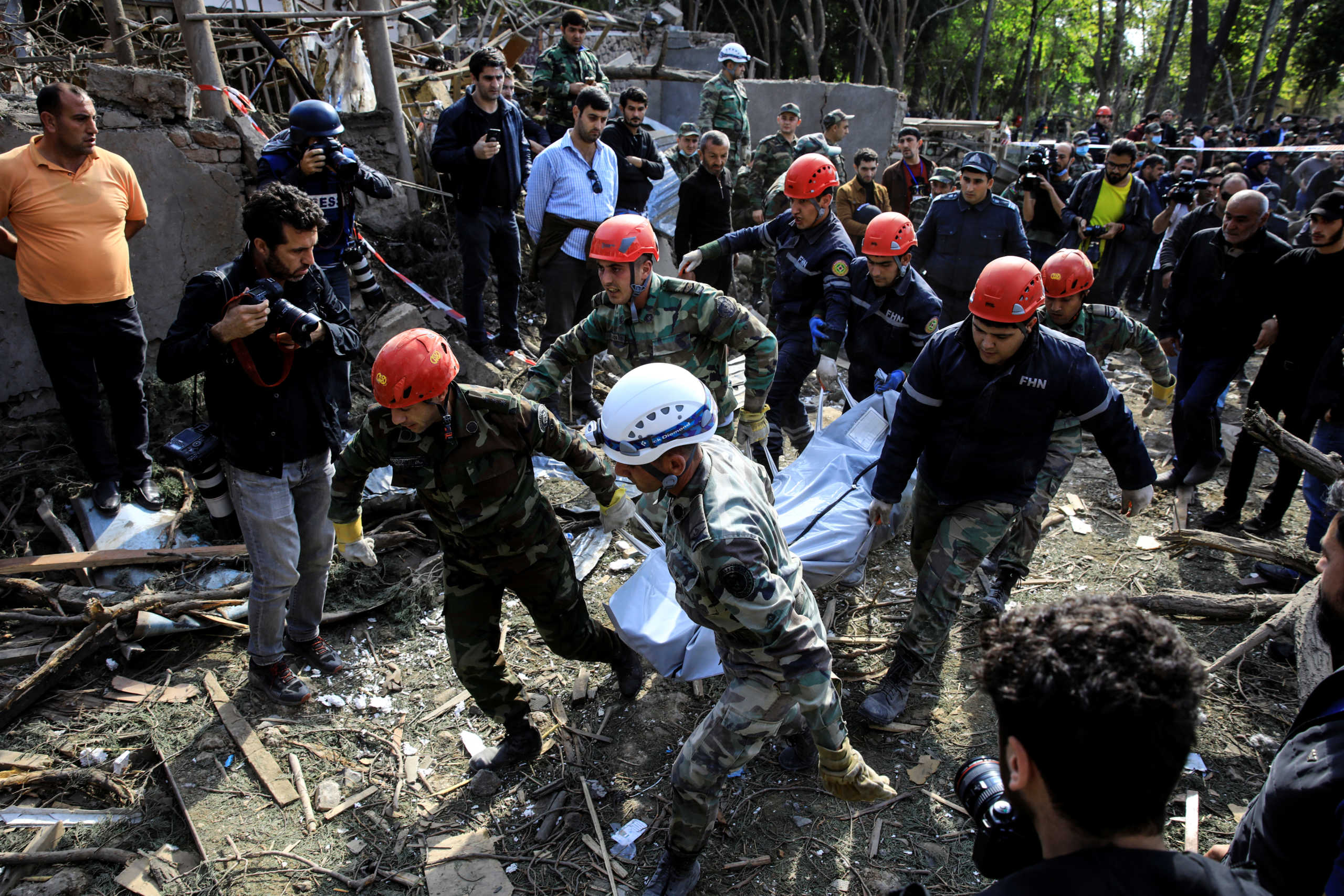 Search and rescue teams carry the body of a victim away from the blast site hit by a rocket during the fighting over the breakaway region of Nagorno-Karabakh in the city of Ganja, Azerbaijan October 11, 2020. REUTERS