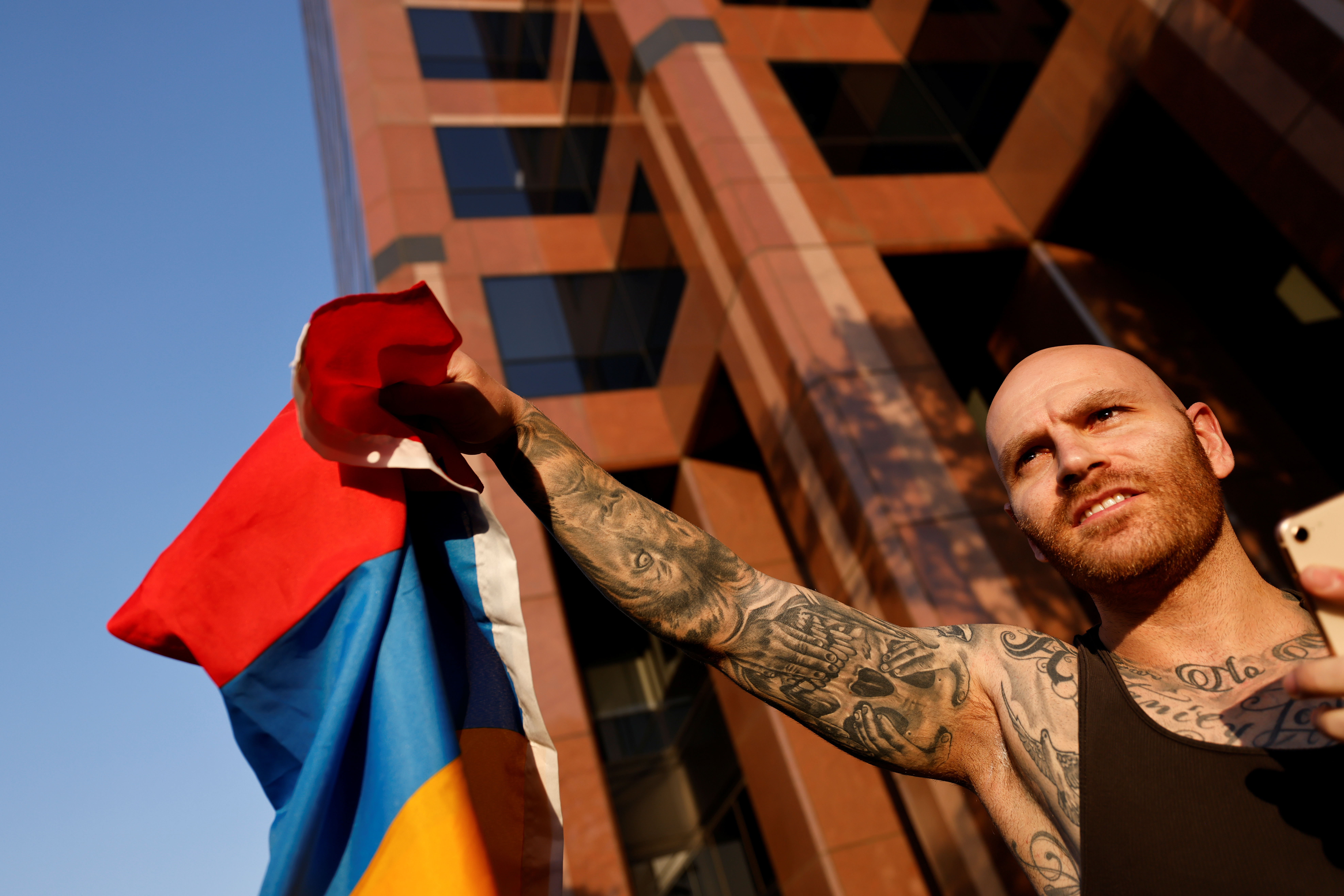 A man holds and Armenian flag during a protest by Armenian Youth Federation against what they call Azerbaijan's aggression against Armenia and the breakaway Nagorno-Karabakh region outside the Azerbaijani Consulate General in Los Angeles, California, U.S., September 30, 2020. REUTERS