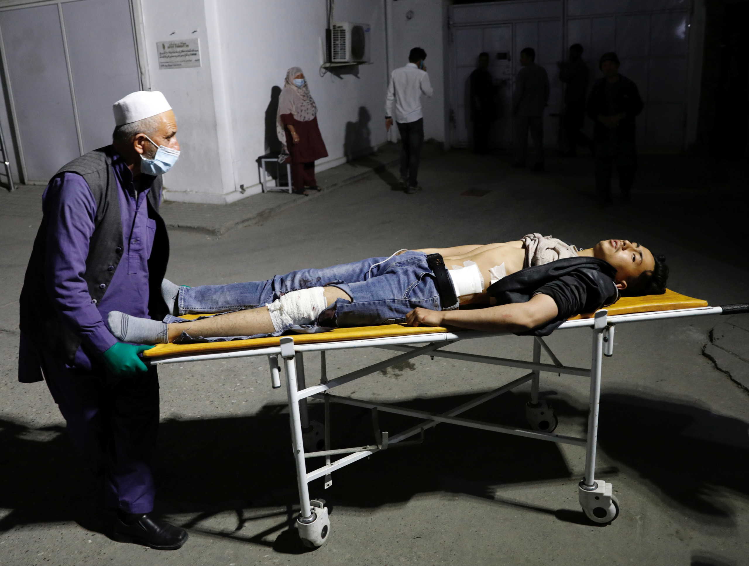 An Afghan man wheels an injured man in a hospital after a suicide bombing in Kabul, Afghanistan October 24, 2020. REUTERS