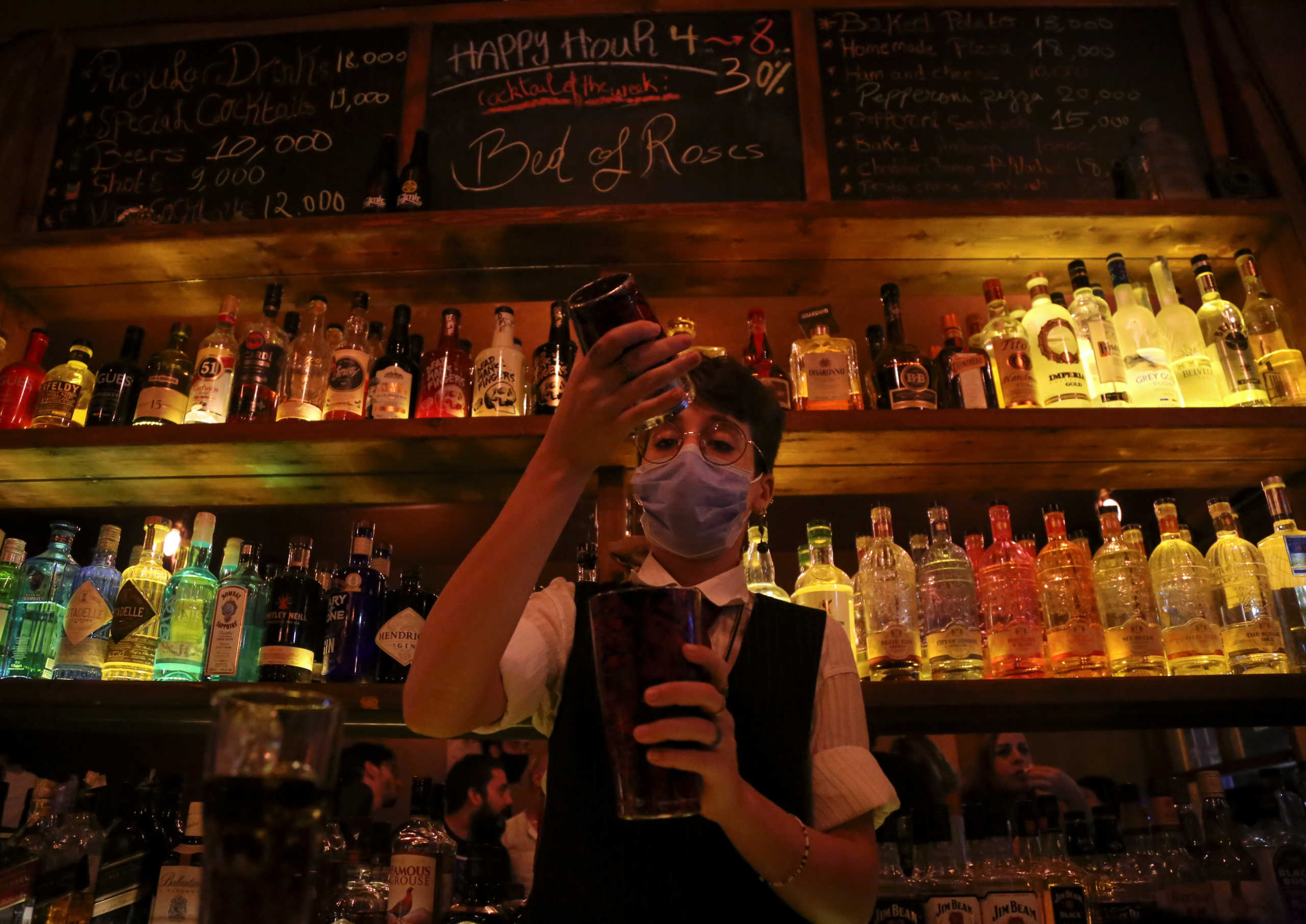 A female bartender wearing a protective face mask mixes an alcoholic drink at a bar, amid concerns over the spread of the coronavirus disease (COVID-19), in Beirut, Lebanon October 9, 2020. Picture taken October 9, 2020. REUTERS