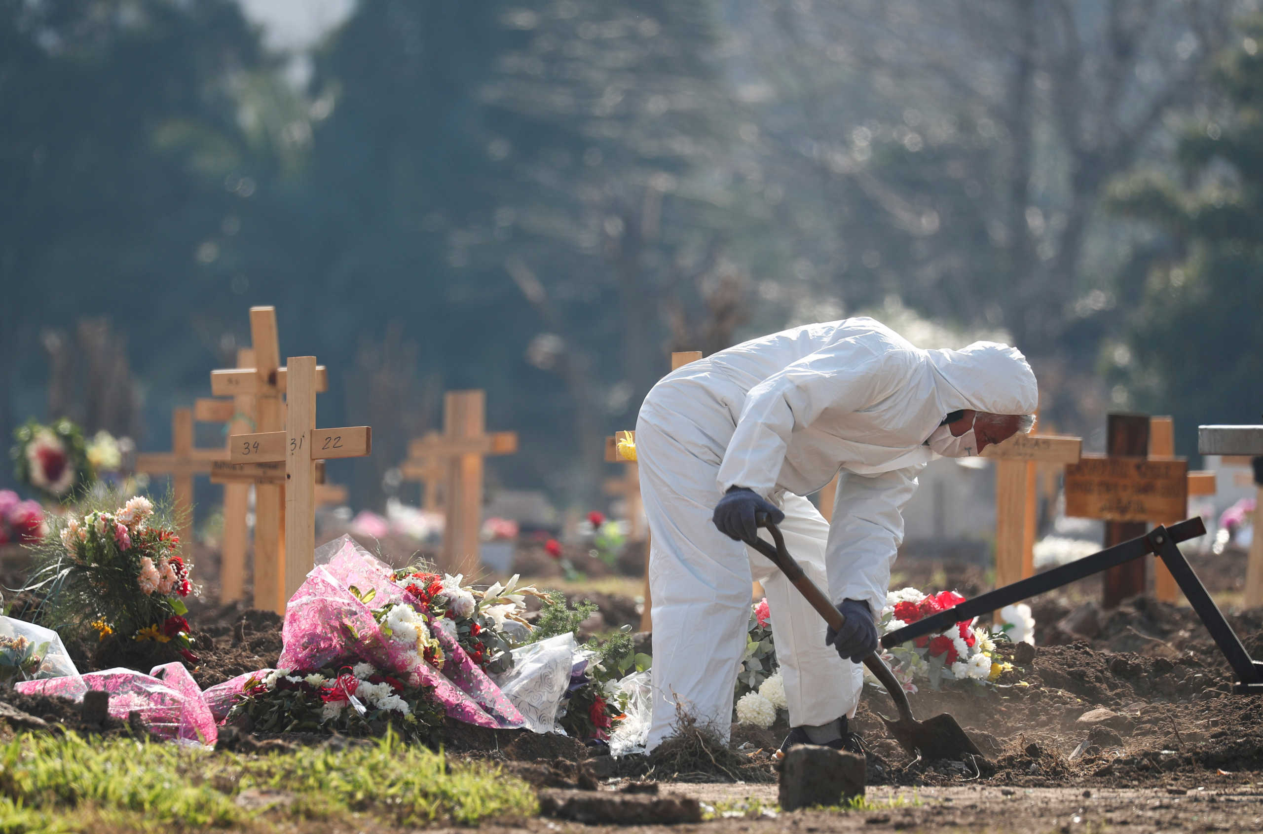 FILE PHOTO: A cemetery worker wearing protective equipment digs a new grave at the Flores cemetery, amid the outbreak of the coronavirus disease (COVID-19) in Buenos Aires, Argentina August 13, 2020. REUTERS