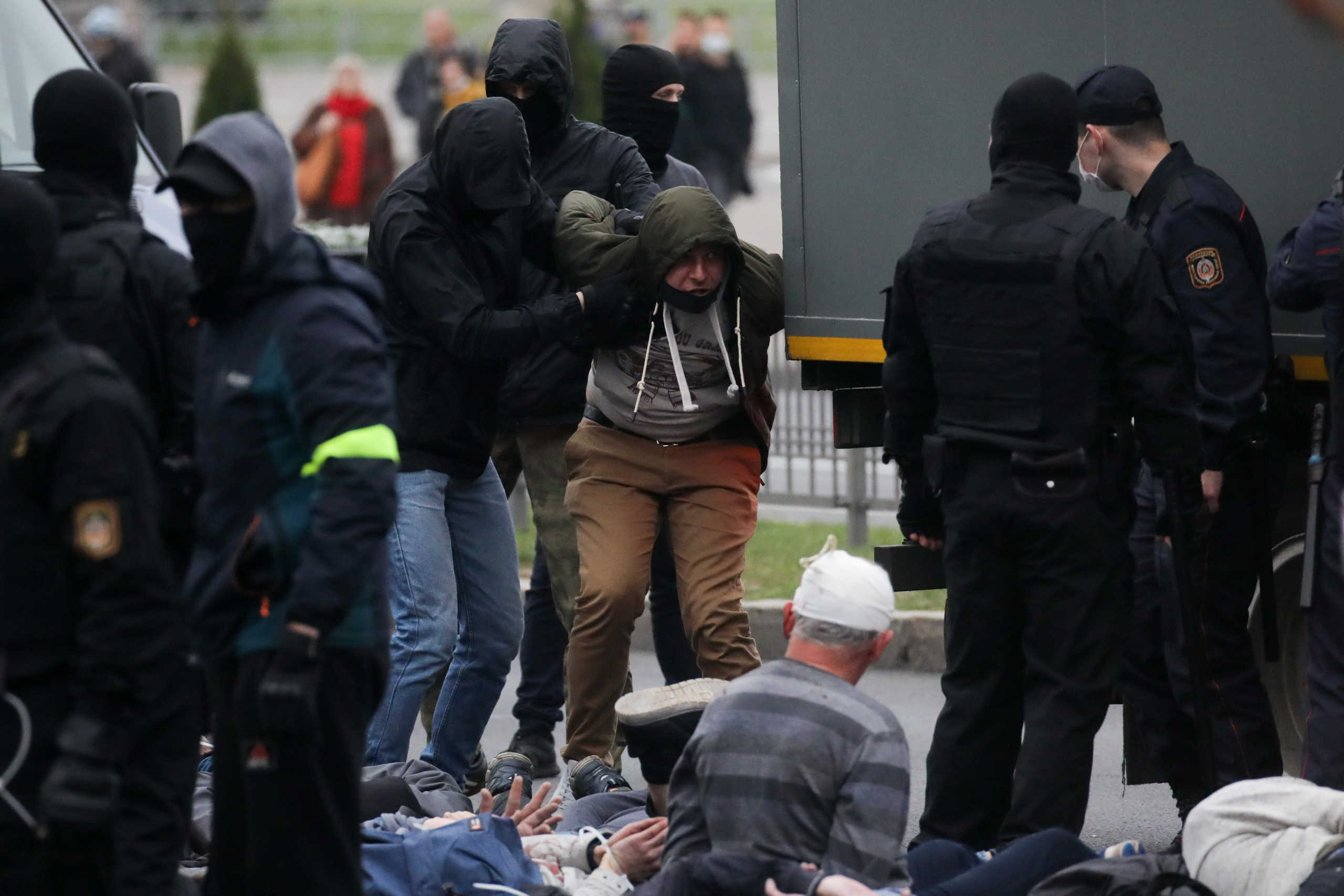 Belarusian law enforcement officers stand next to detained participants of an opposition rally to reject the presidential election results in Minsk, Belarus October 11, 2020. BelaPAN via REUTERS  ATTENTION EDITORS - THIS IMAGE WAS PROVIDED BY A THIRD PARTY. MANDATORY CREDIT.
