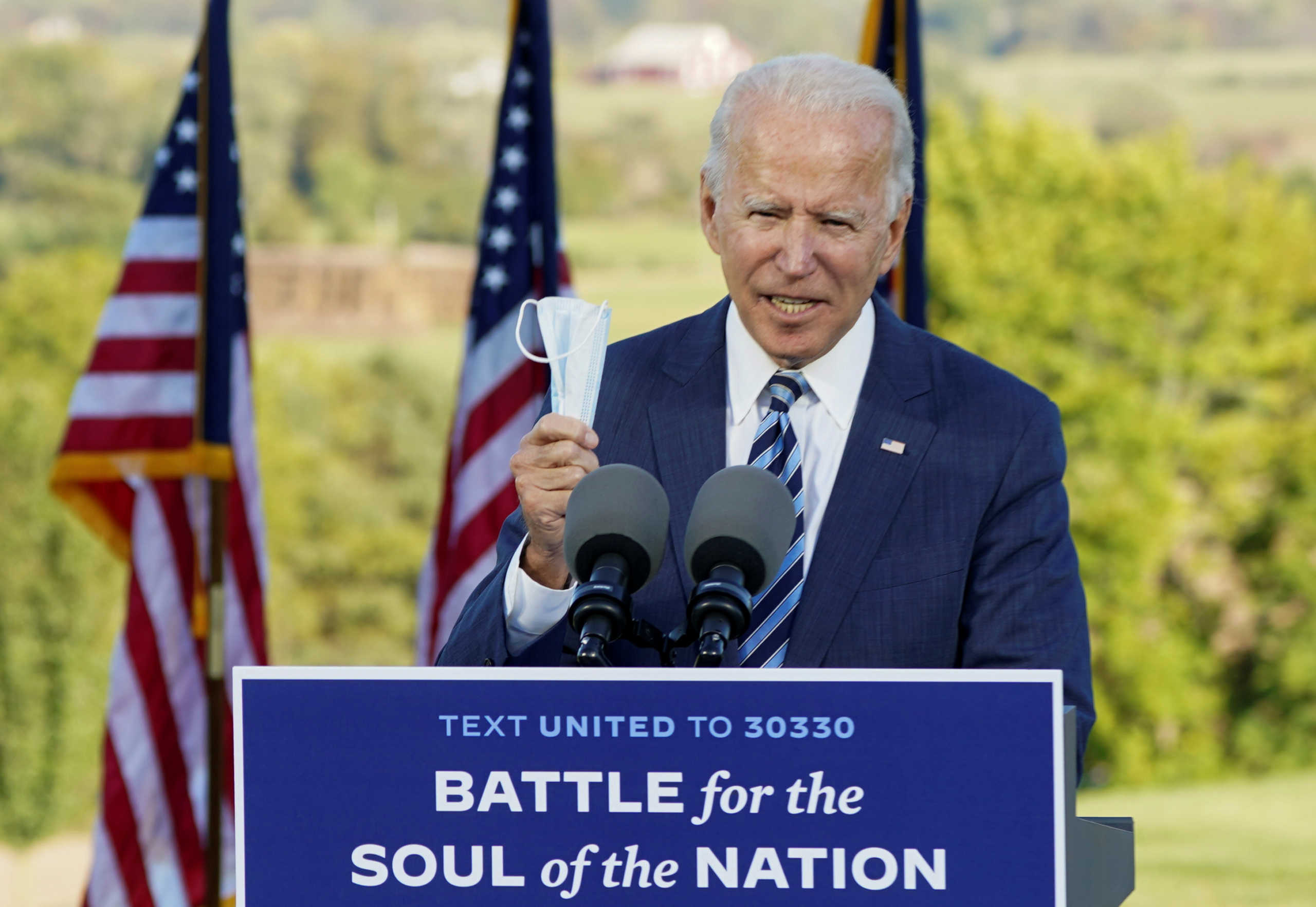 Democratic U.S. presidential nominee Joe Biden holds up his face mask while speaking during a campaign stop in Gettysburg, Pennsylvania, U.S., October 6, 2020. REUTERS