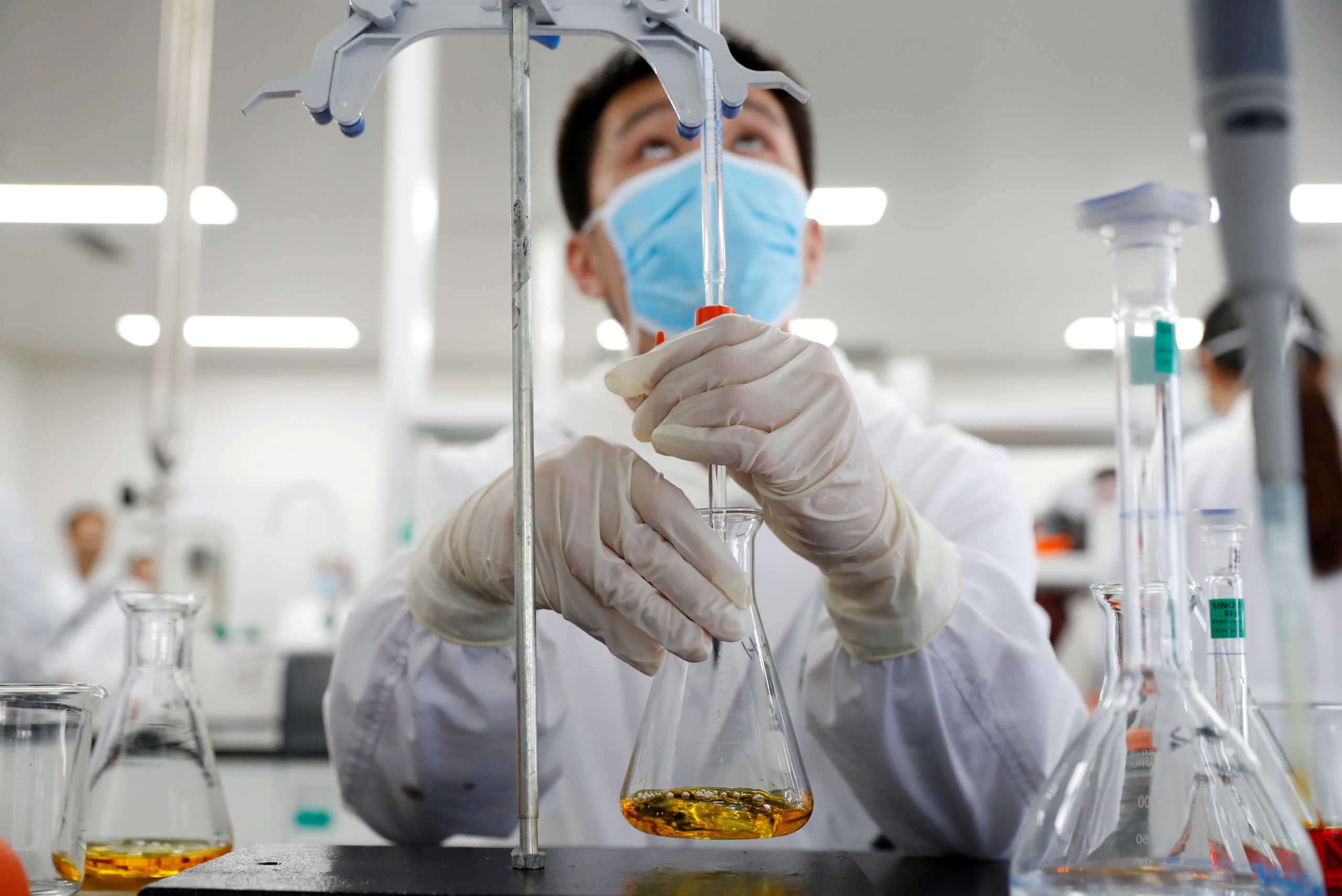 FILE PHOTO: A man works in a laboratory of Chinese vaccine maker Sinovac Biotech, developing an experimental coronavirus disease (COVID-19) vaccine, during a government-organized media tour in Beijing, China, September 24, 2020. REUTERS