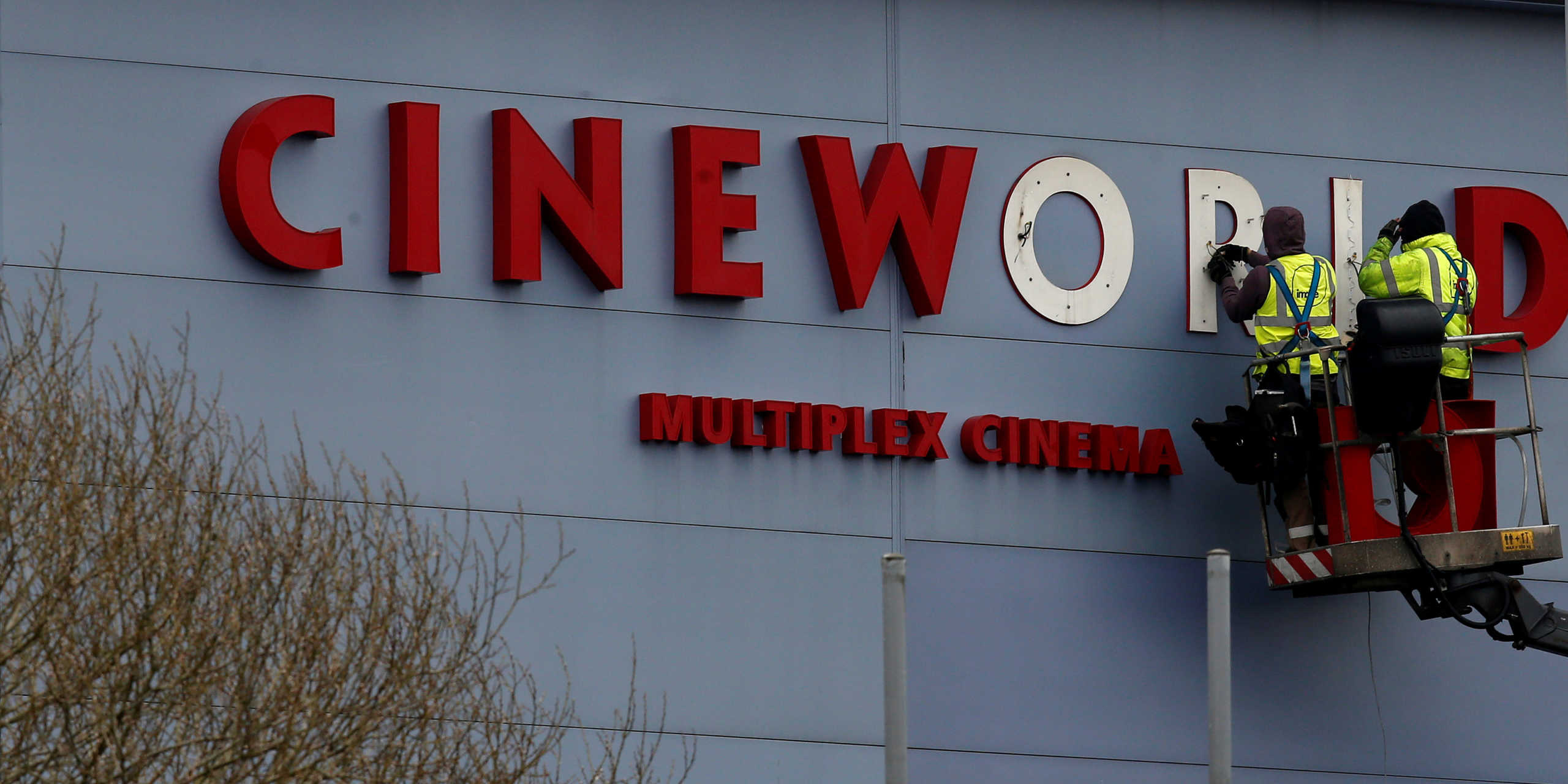 FILE PHOTO: Workers repair a sign at a Cineworld cinema in Bradford northern England, March 24, 2016. REUTERS