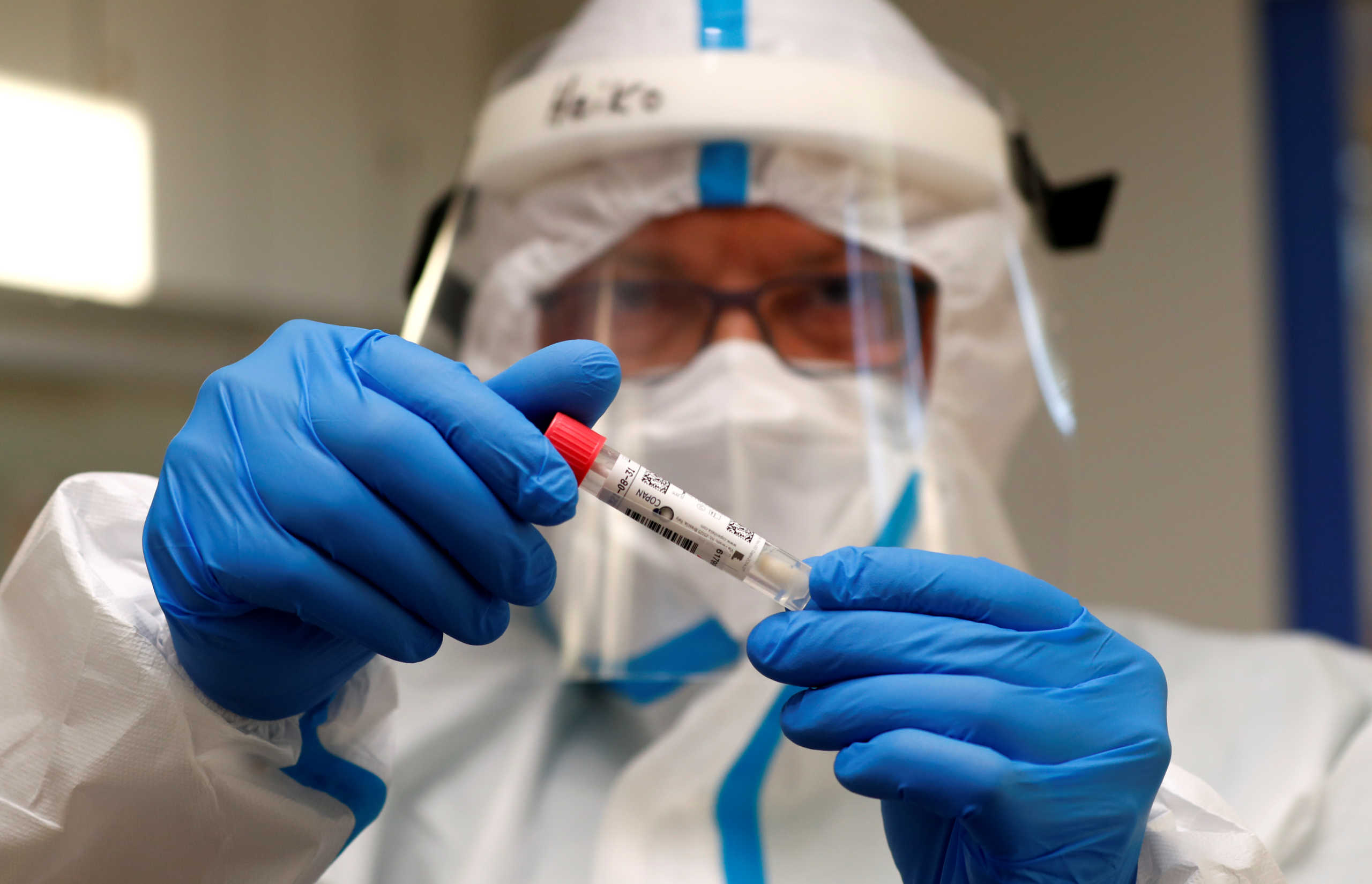 A German Red Cross medical staff holds a smear-test stick of a traveller who returned from the Ukraine, after a voluntary coronavirus disease (COVID-19) test at the new Corona test station of the central bus location in Berlin, Germany, August 5, 2020.      REUTERS