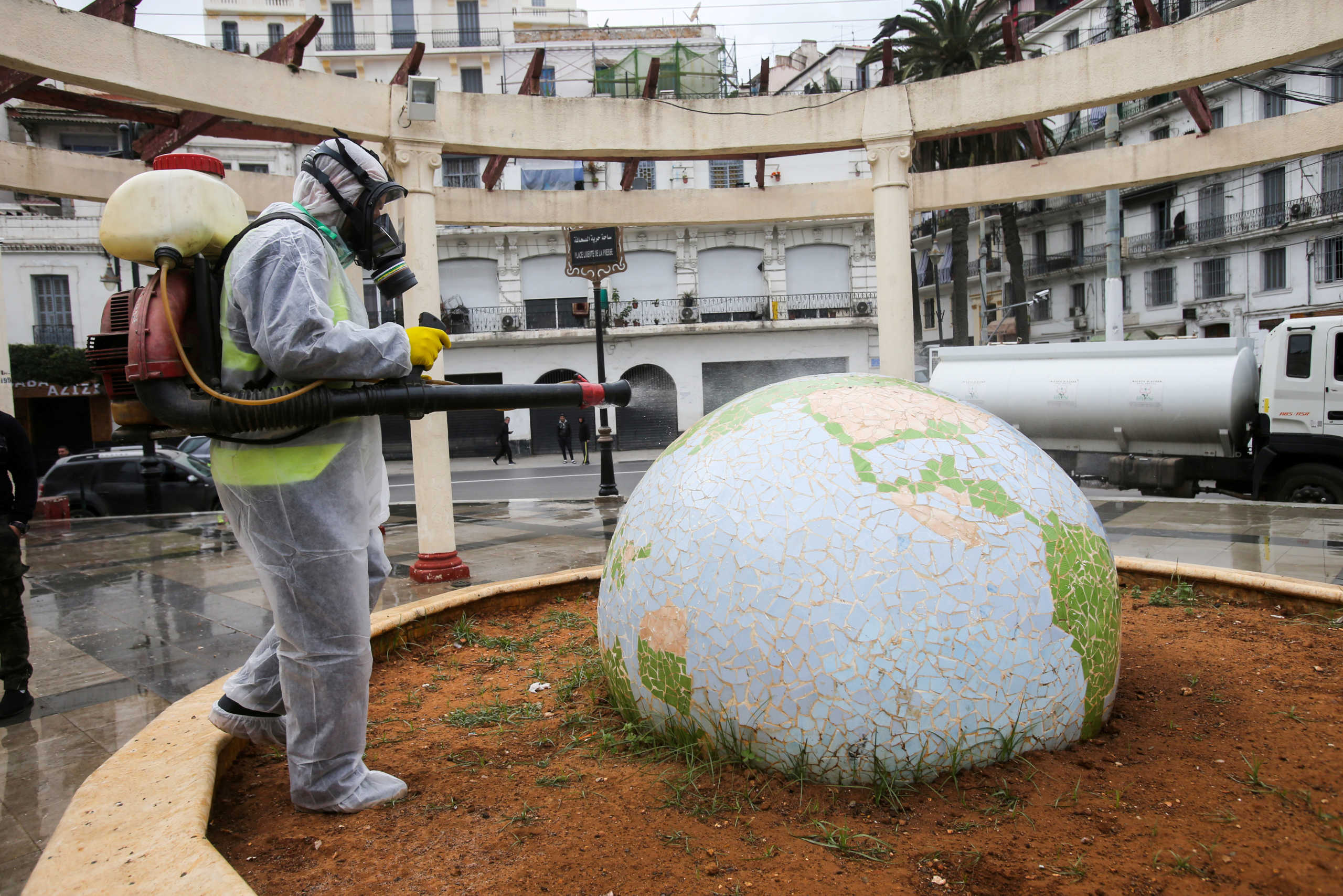 FILE PHOTO: A worker wearing a protective suit disinfects a globe-shaped public garden, following the outbreak of coronavirus disease (COVID-19), in Algiers, Algeria March 23, 2020. REUTERS