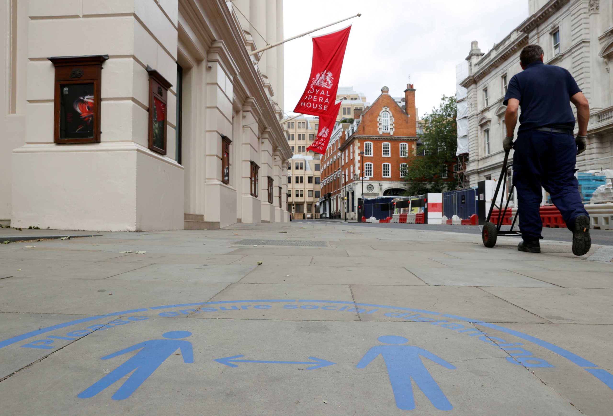 FILE PHOTO: Social distancing signs are seen marked on the street outside The Royal Opera House, following the coronavirus disease (COVID-19) outbreak, in London, Britain July 6, 2020. REUTERS