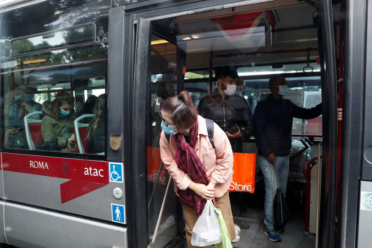 A passenger wearing a protective face mask looks out of a bus, as Italy adopts new restrictions aimed at curbing a surge in the coronavirus disease (COVID-19) infections, in Rome, Italy October 15, 2020. REUTERS