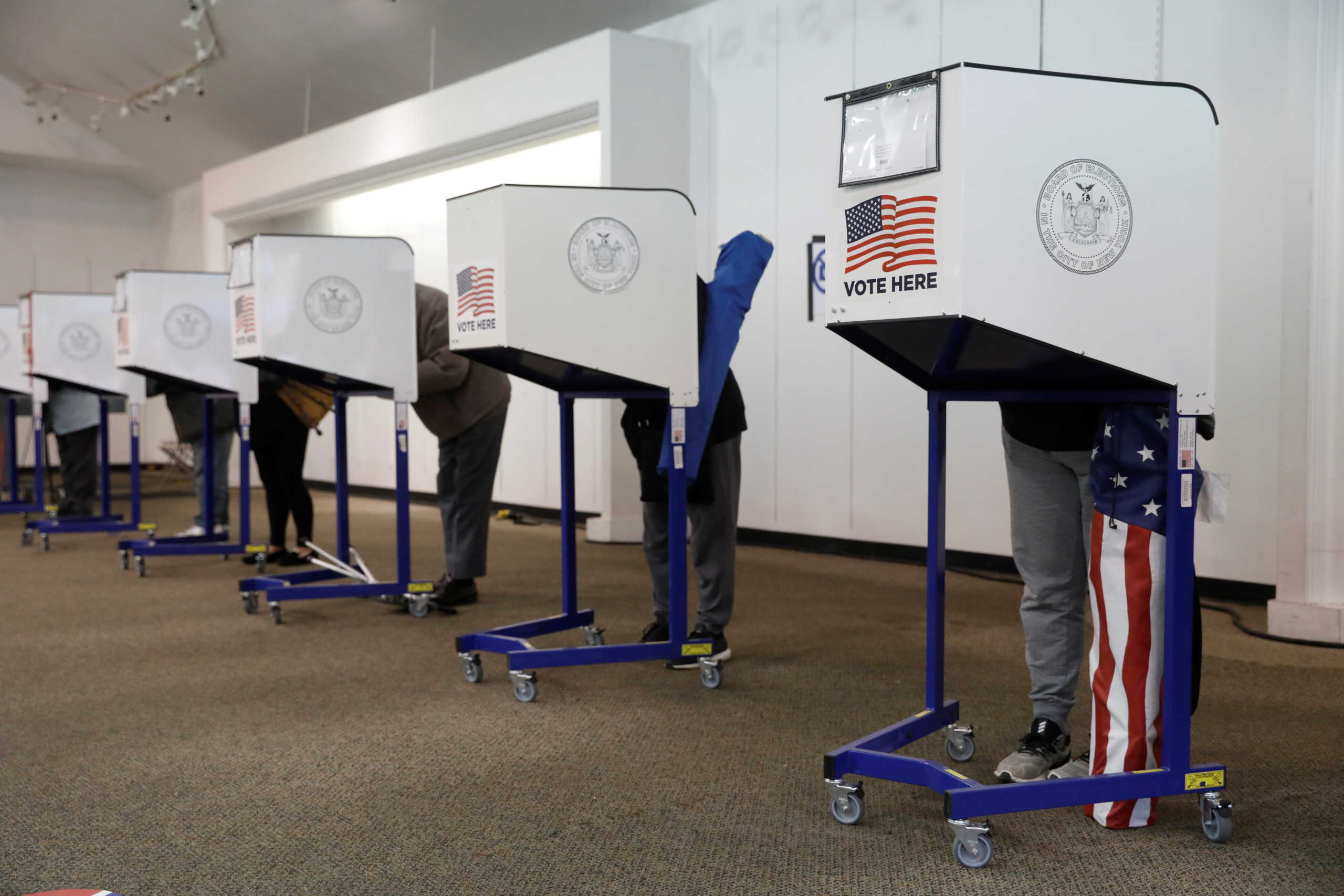 People complete ballots in privacy booths during early voting at a polling station in The Bronx, New York City, U.S., October 25, 2020. REUTERS