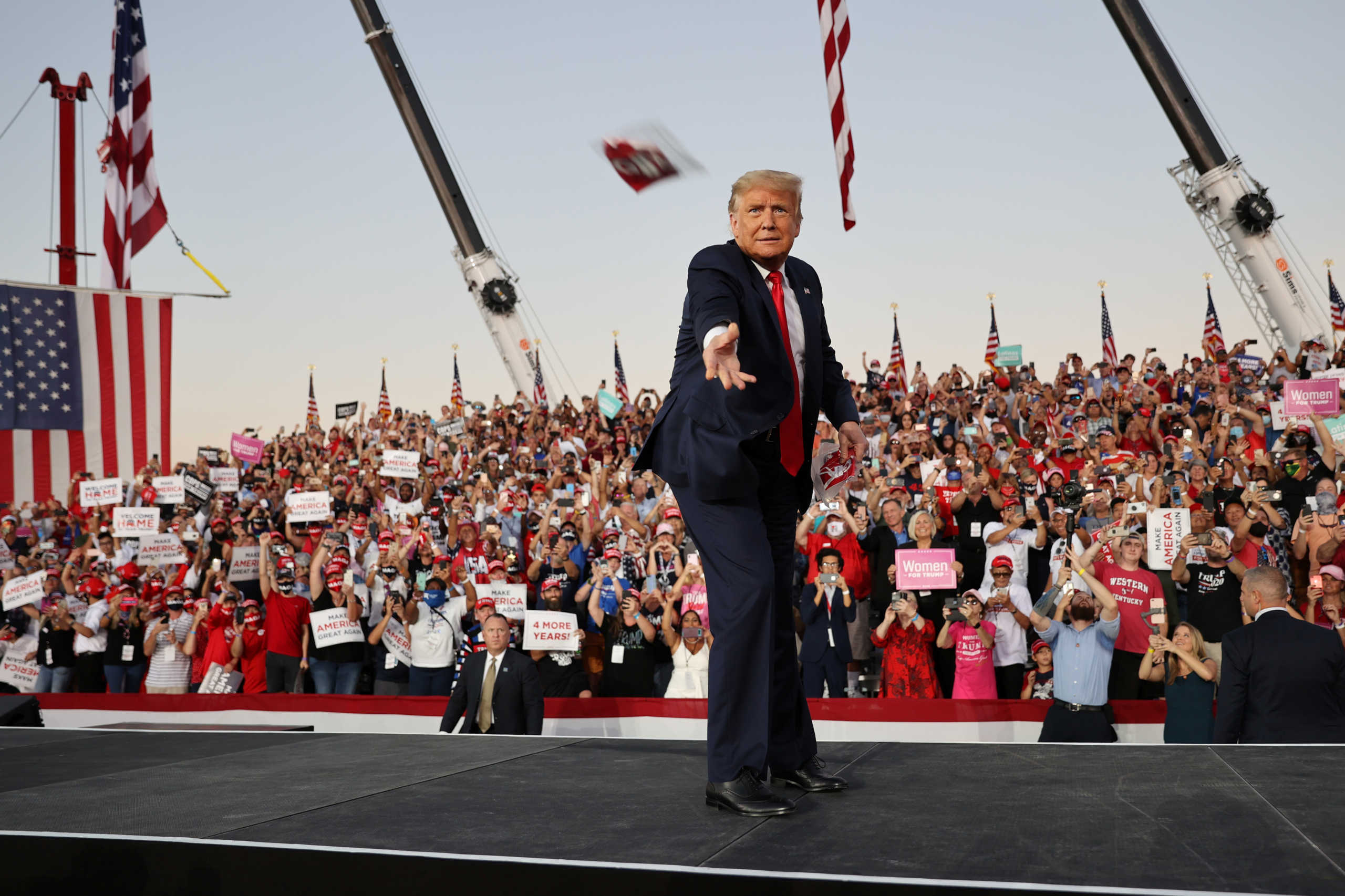 U.S. President Donald Trump tosses face masks to the crowd as he takes the stage for a campaign rally, his first since being treated for the coronavirus disease (COVID-19), at Orlando Sanford International Airport in Sanford, Florida, U.S., October 12, 2020. REUTERS