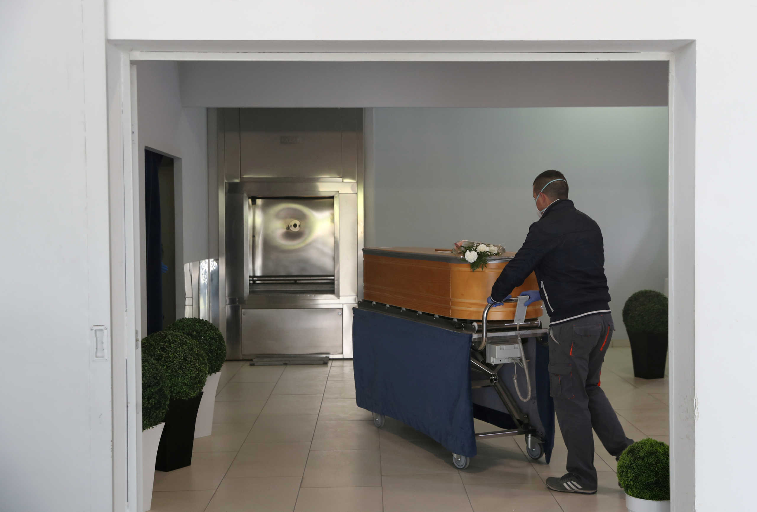 FILE PHOTO: Diego Gonzalez, a funeral home worker, is seen at the Santa Teresa crematorium pushing a coffin with a COVID-19 victim to be cremated, amid the coronavirus disease (COVID-19) outbreak in Segovia, Spain, April 23, 2020. REUTERS