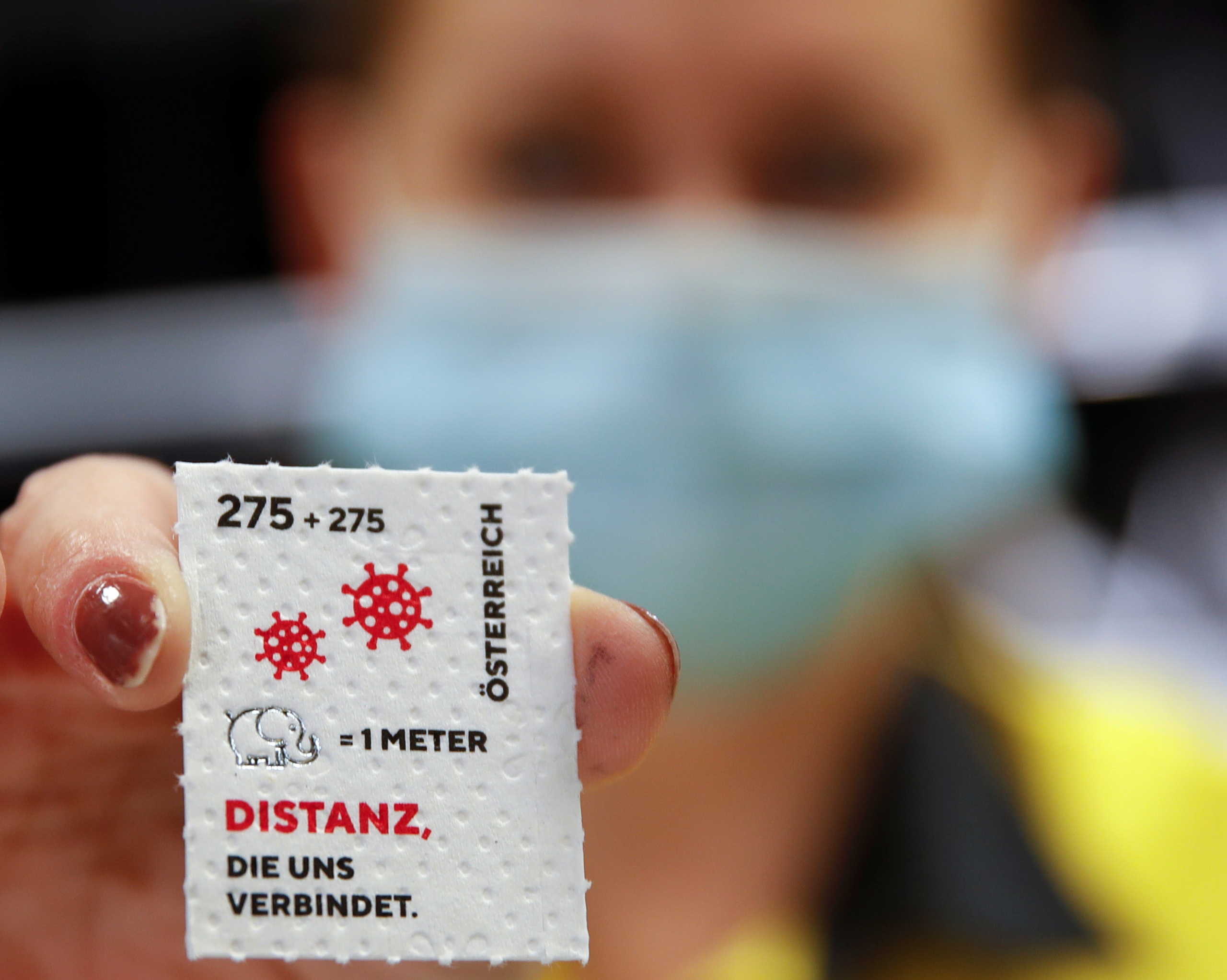 An employee of the Austrian postal service displays a so called "corona stamp" in a post office, as the 2.75 euro "corona stamp" is printed on three-ply toilet paper and sold individually as part of a 10 cm wide sheet, in Vienna, Austria October 23, 2020. REUTERS