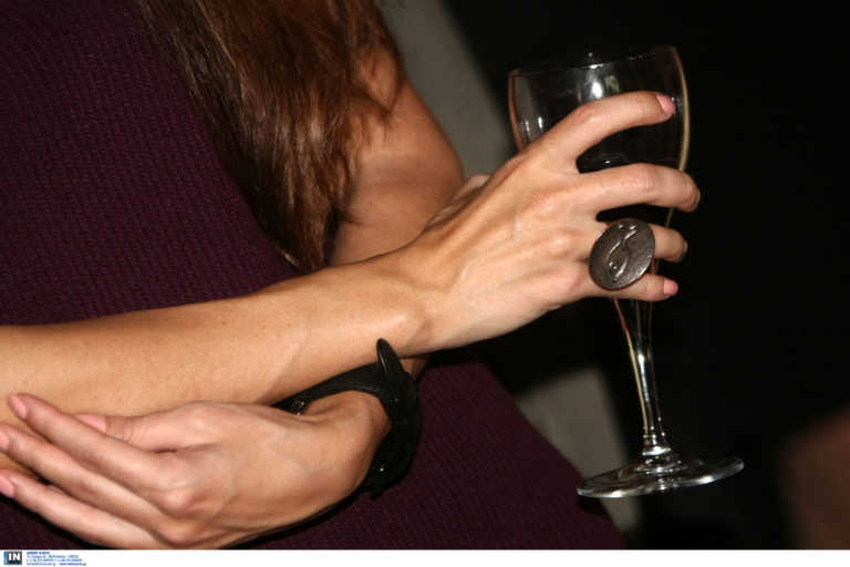 μία γυναίκα κρατάει ένα ποτήρι