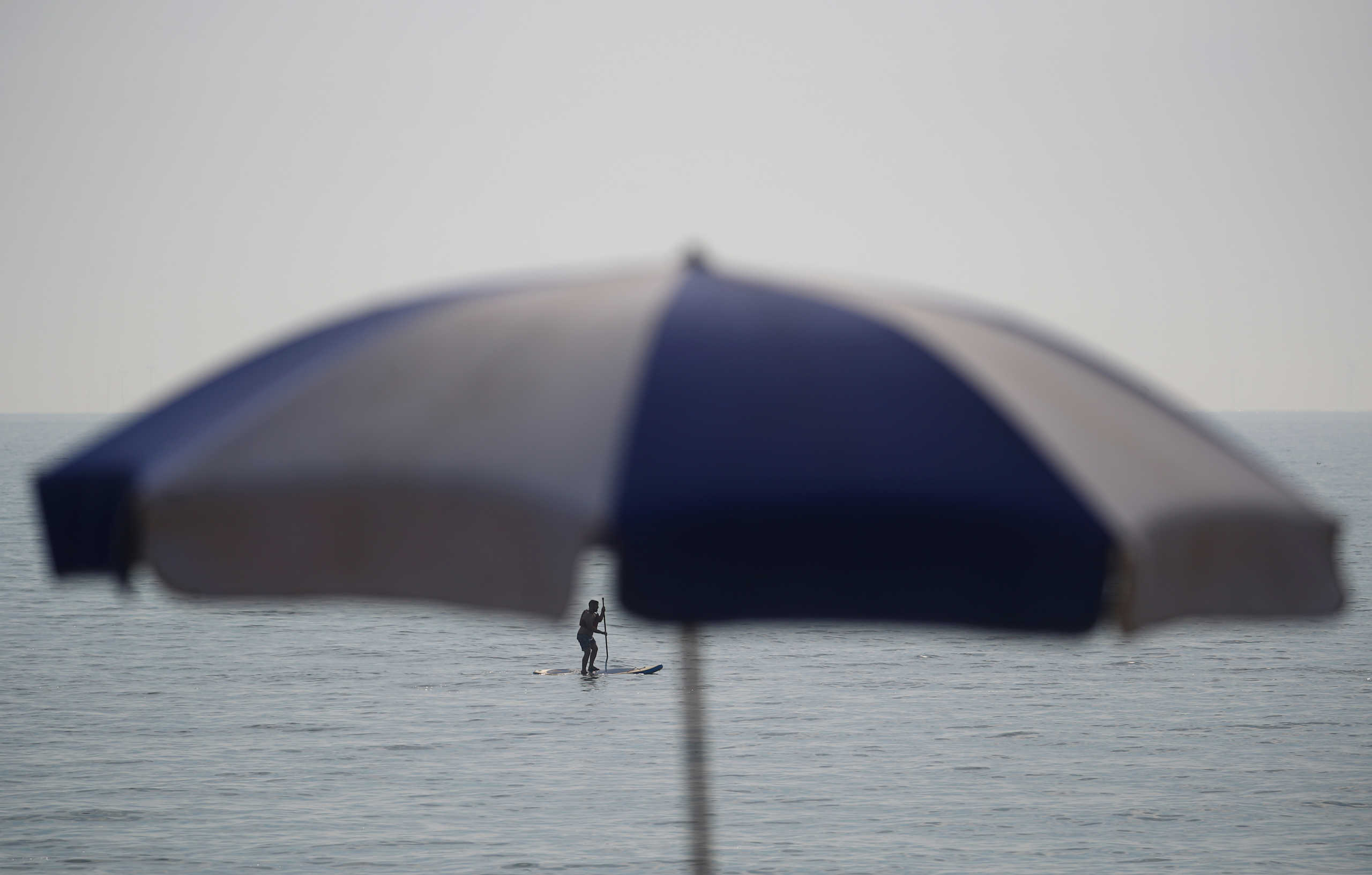A person uses paddle board during hot weather at Brighton beach in Brighton, Britain September 15, 2020. REUTERS