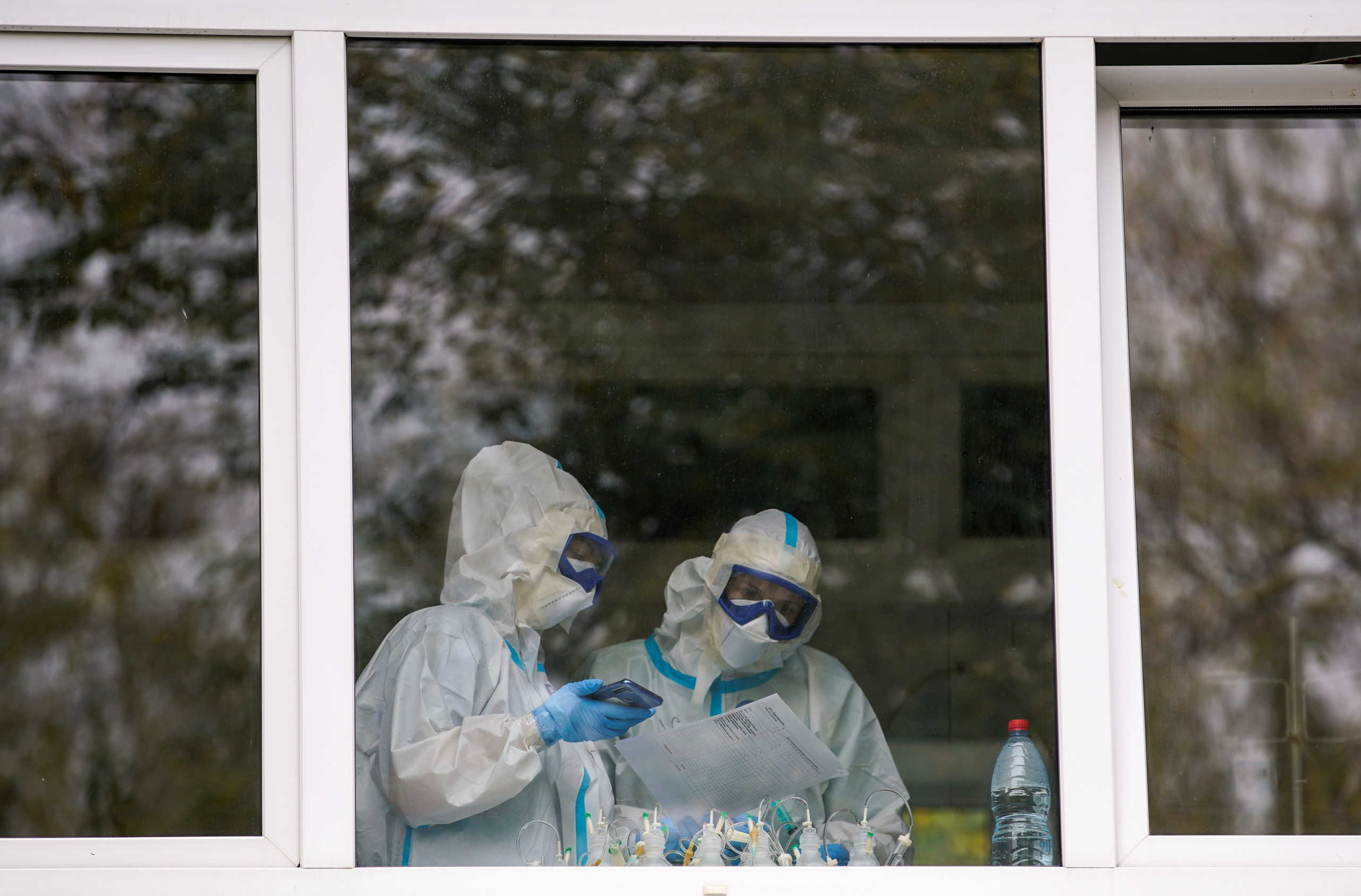 Medics wearing protective suits are seen in a window of a hospital where patients suffering from the coronavirus disease (COVID-19)) are treated, in Tver, Russia October 13, 2020.  REUTERS
