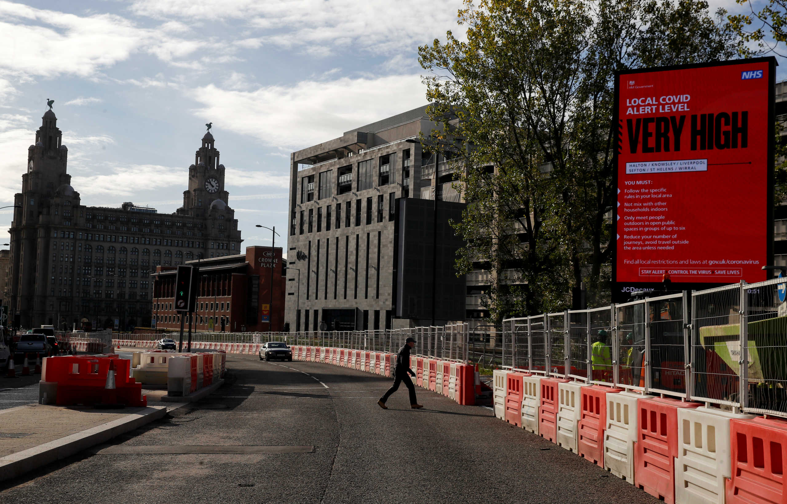 A covid warning sign stands in the vicinity of the Royal Liver building, as the spread of the coronavirus disease (COVID-19) continues, in Liverpool, Britain October 15, 2020. REUTERS