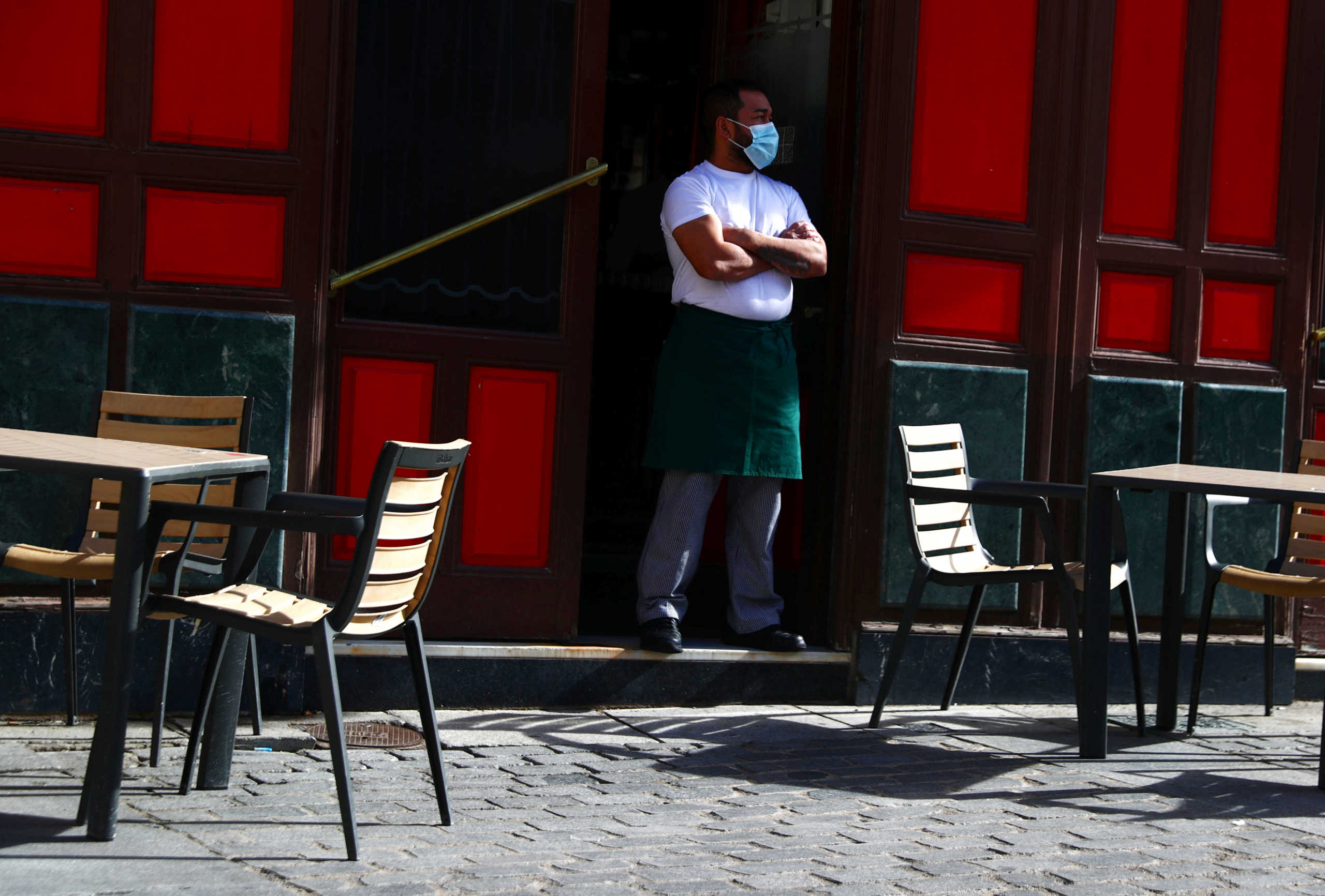 A waiter wearing a protective face mask waits for customers in his terrace amid the outbreak of the coronavirus disease (COVID-19), in Madrid, Spain October 1, 2020. REUTERS