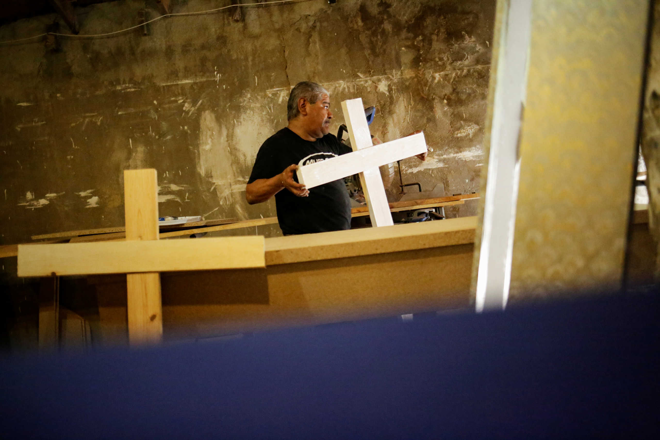 An employee of the Rios funeral home carries a wooden cross at a workshop to be used in burials, as the outbreak of the coronavirus disease (COVID-19) continues in Ciudad Juarez, Mexico October 7, 2020. REUTERS
