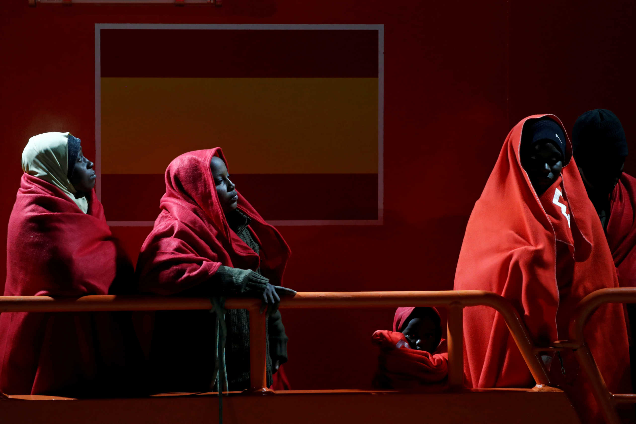FILE PHOTO: Migrant women and a child, intercepted off the coast in the Mediterranean Sea, wait to disembark from a rescue boat at the port of Malaga, southern Spain, March 7, 2020. REUTERS