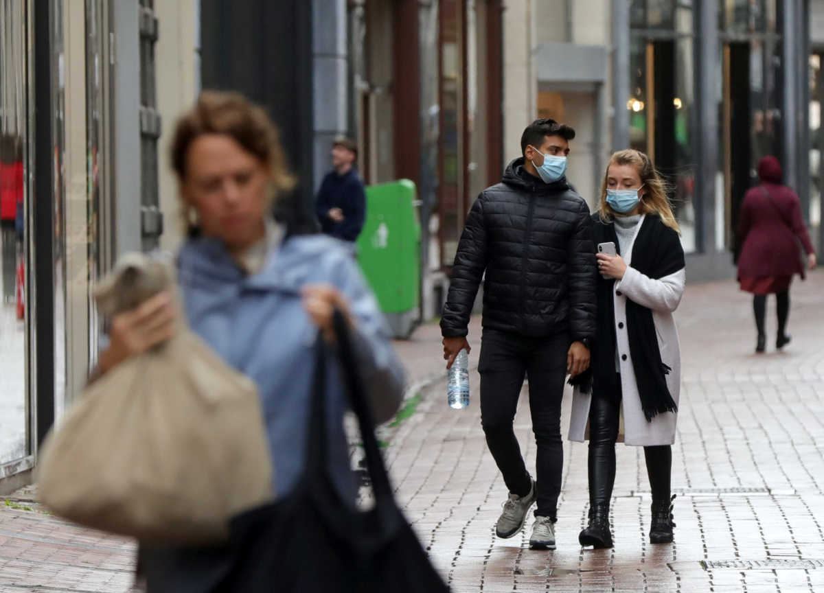 περαστικοί με μάσκα για κορονοϊό στο Άμστερνταμ