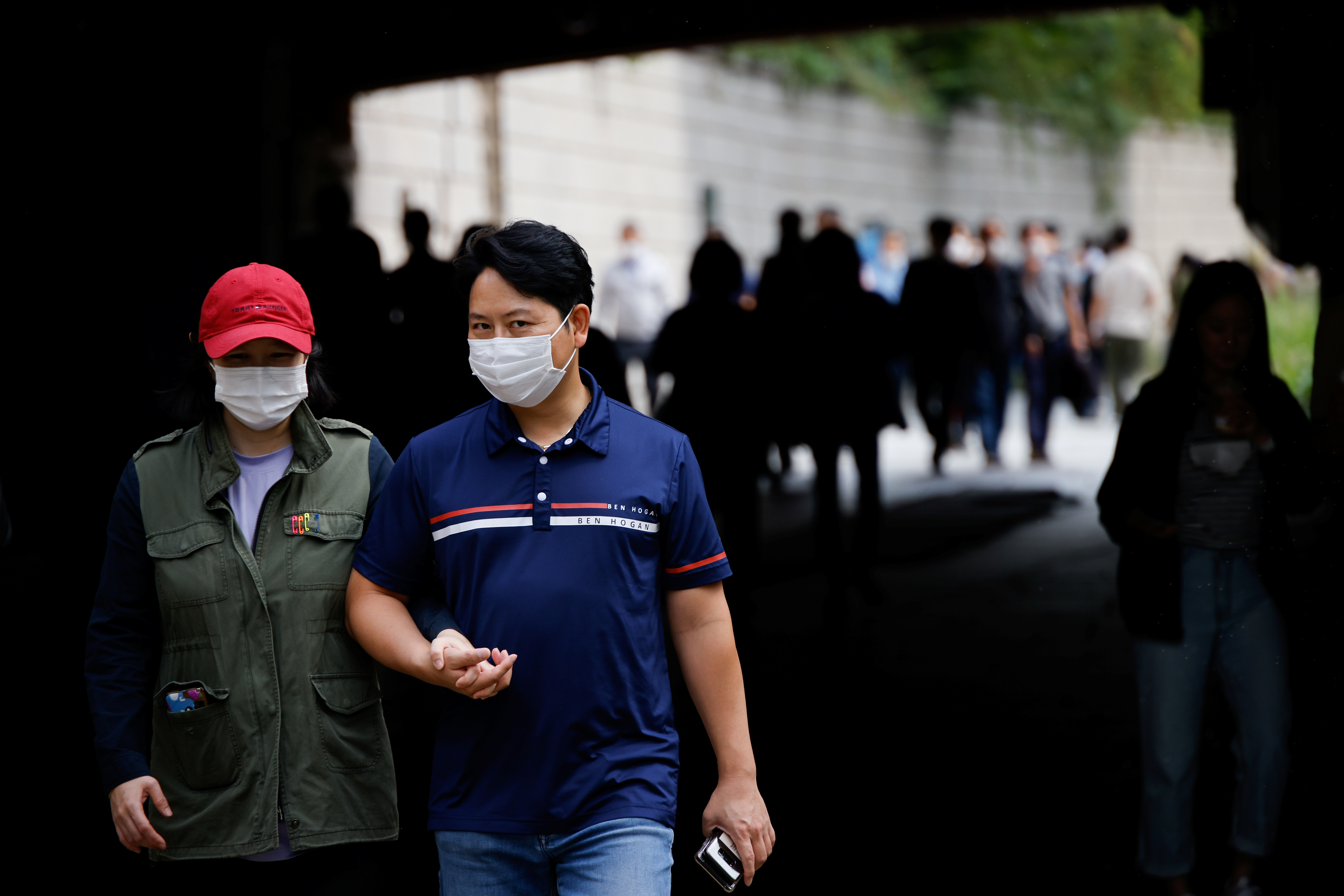 A couple wearing masks takes a walk amid the coronavirus disease (COVID-19) outbreak at the Cheonggye stream in Seoul, South Korea, September 29, 2020.    REUTERS