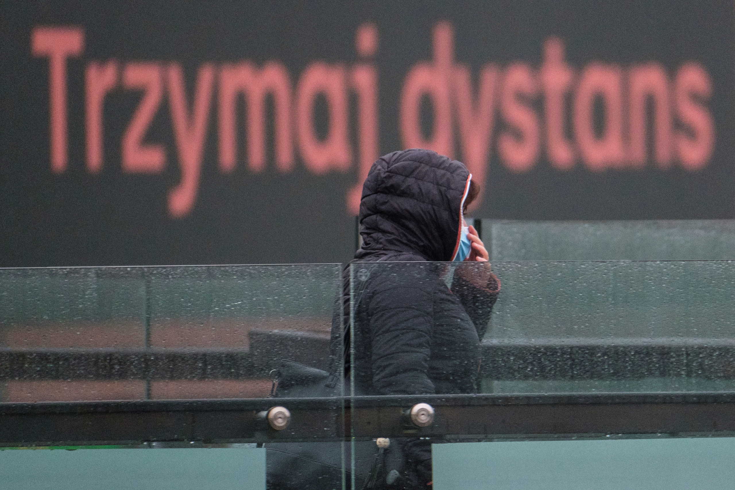 Woman wears a mask amid coronavirus disease (COVID-19) restrictions in Rzeszow, Poland, October 16, 2020. Sign reads "Keep distance". Patryk Ogorzalek