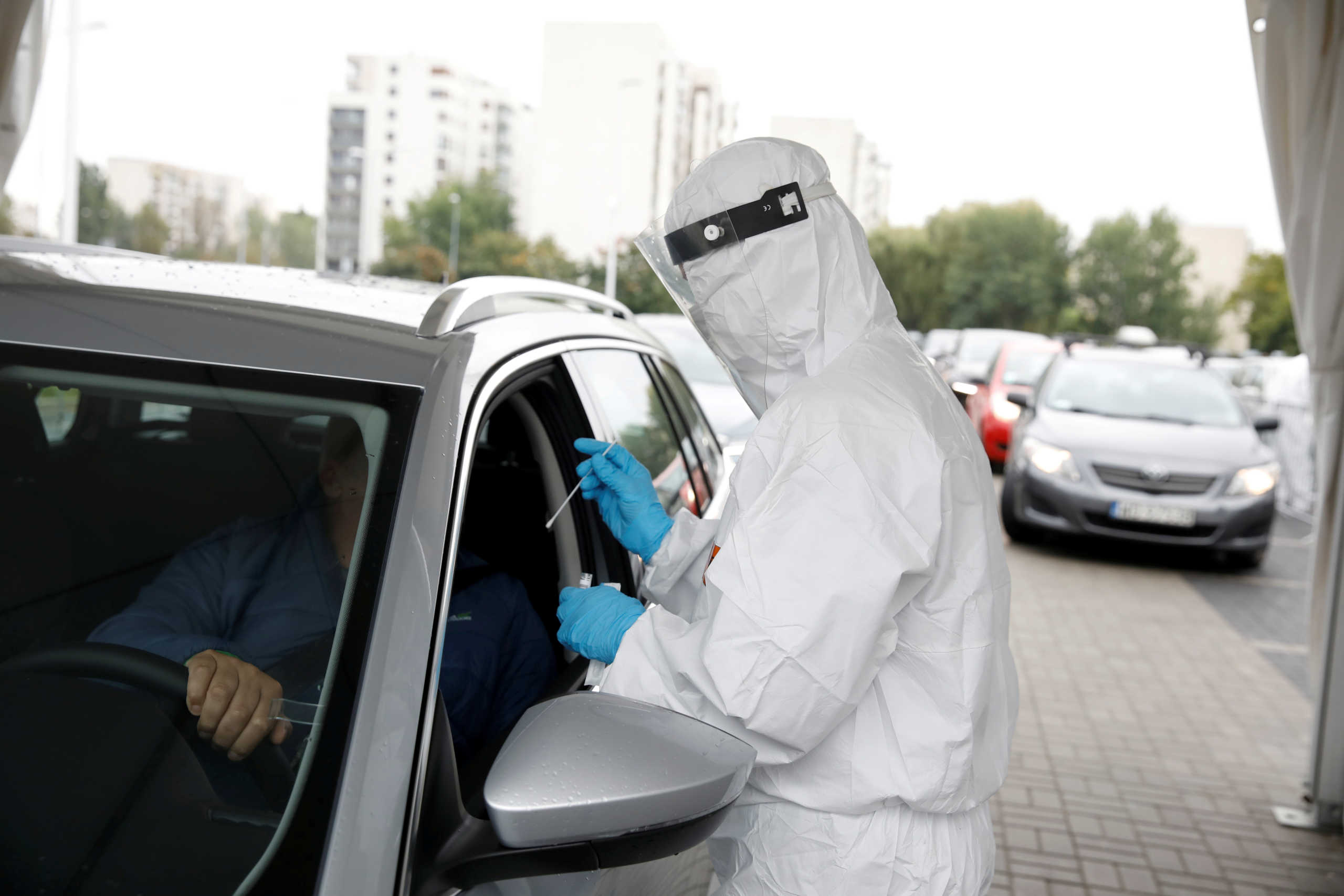 FILE PHOTO: People are tested for the coronavirus disease (COVID-19) at a drive-thru testing centre in Warsaw, Poland, October 2, 2020. REUTERS