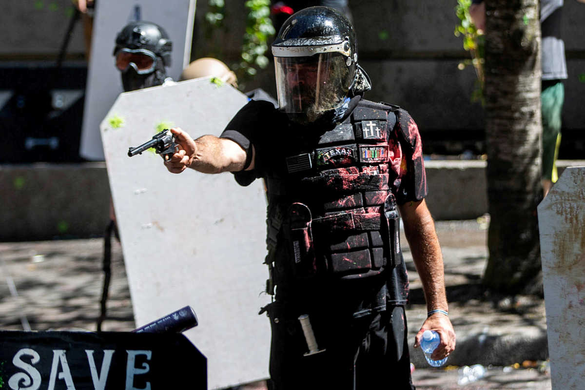 FILE PHOTO: Alan Swinney points a gun during clashes between groups like Proud Boys and Patriot Prayer, and protesters against police brutality and racial injustice in Portland, Oregon, U.S., August 22, 2020. REUTERS