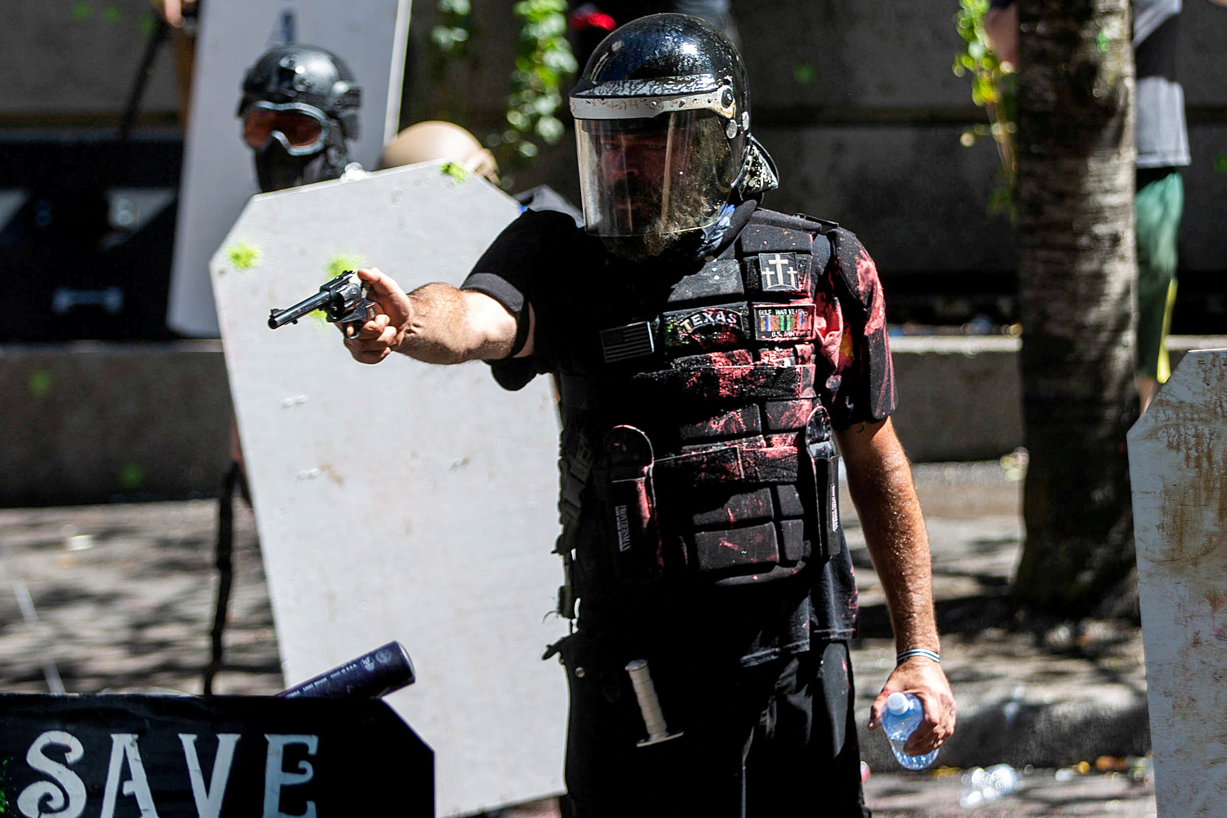 FILE PHOTO: Alan Swinney points a gun during clashes between groups like Proud Boys and Patriot Prayer, and protesters against police brutality and racial injustice in Portland, Oregon, U.S., August 22, 2020. REUTERS