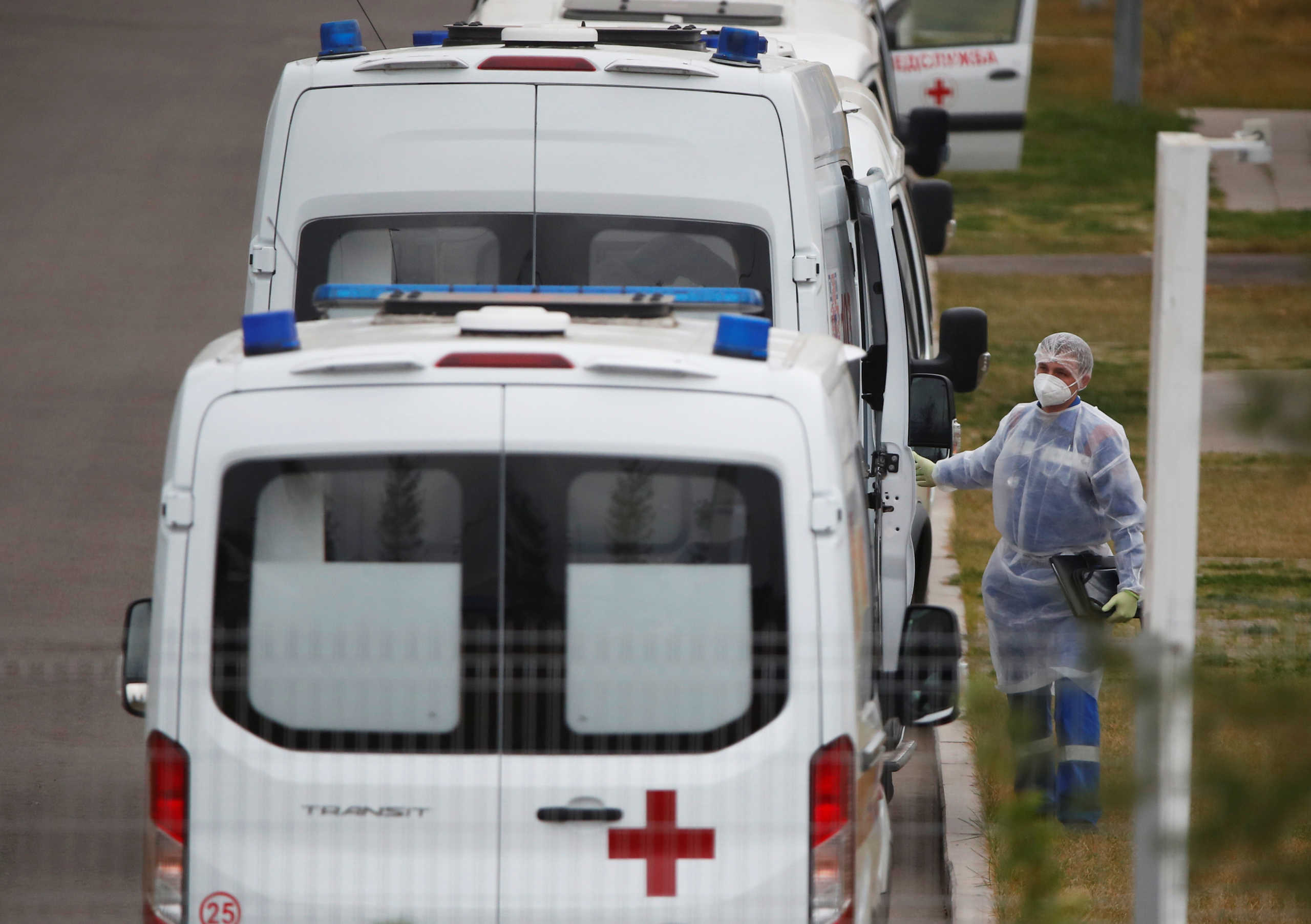 A medical specialist wearing protective gear stands next to an ambulance parked outside a hospital for patients infected with the coronavirus disease (COVID-19) on the outskirts of Moscow, Russia October 7, 2020. REUTERS