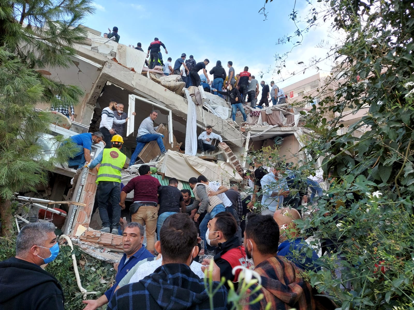 Locals and officials search for survivors at a collapsed building after a strong earthquake struck the Aegean Sea on Friday and was felt in both Greece and Turkey, where some buildings collapsed in the coastal province of Izmir, Turkey, October 30, 2020. REUTERS