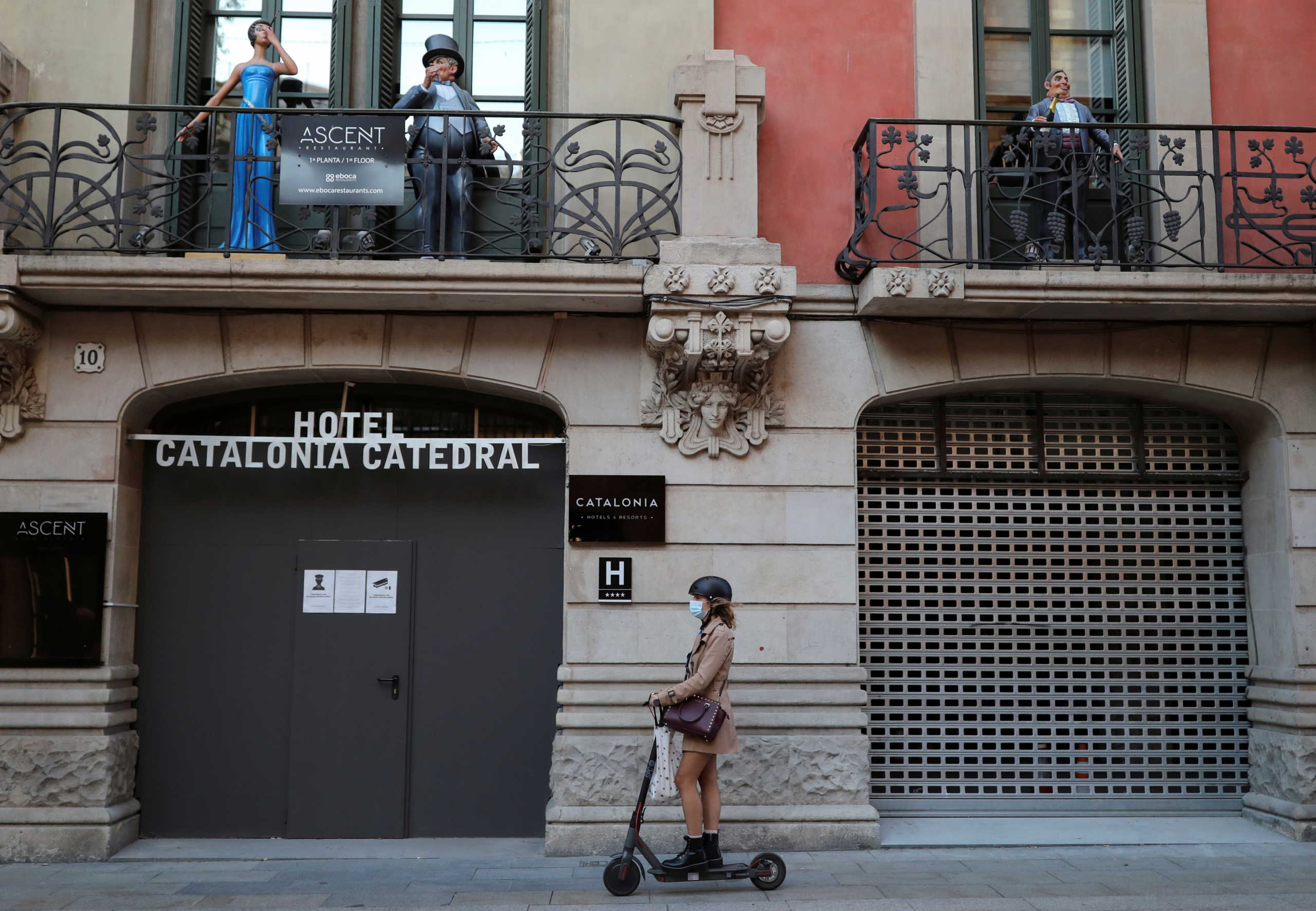 A woman rides a scooter past a closed hotel at Barrio Gotico (Gothic Quarter), after Catalonia's government imposed new restrictions in an effort to control the spread of the coronavirus disease (COVID-19), in Barcelona, Spain October 23, 2020. REUTERS