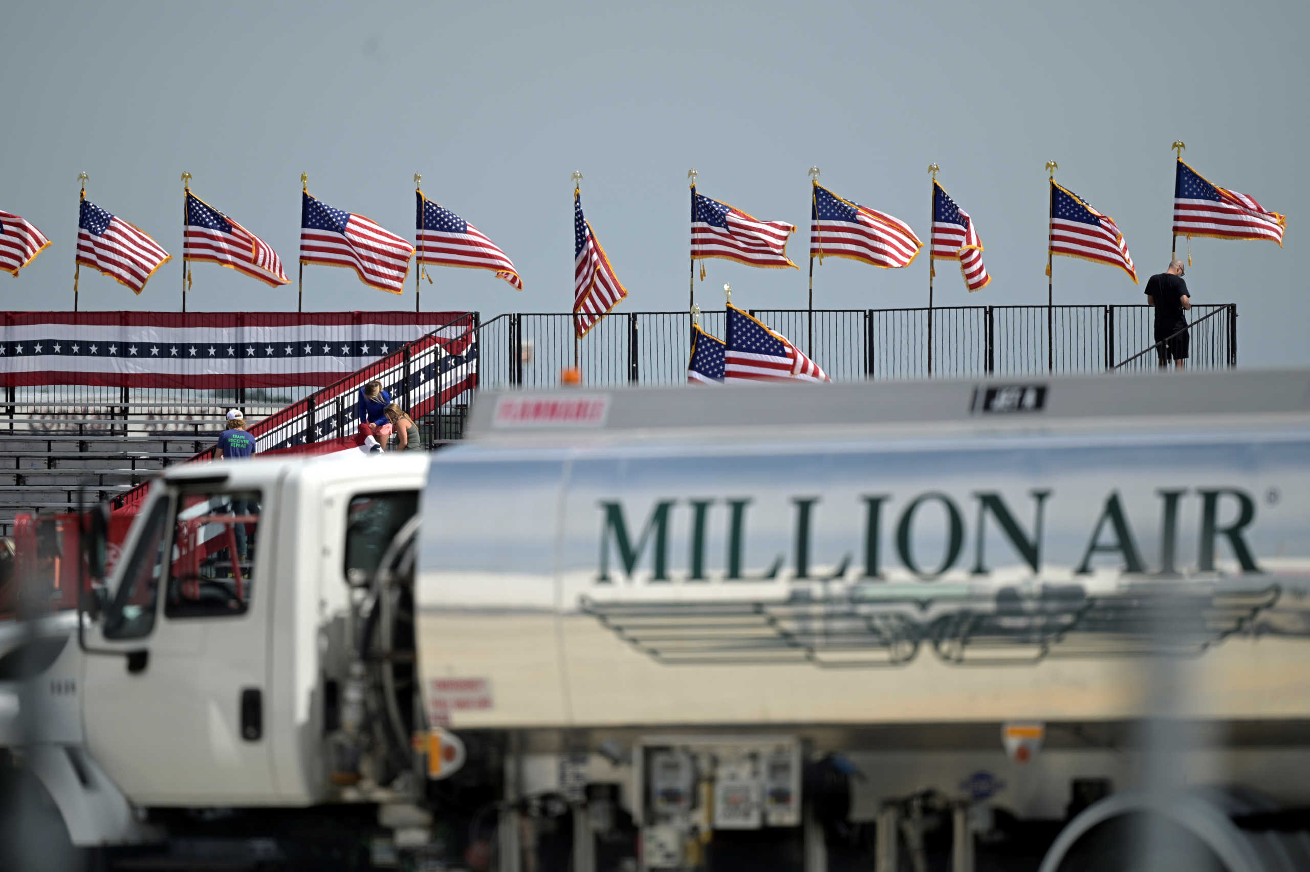 Following U.S. President Donald Trump's announcement that he has tested positive for the coronavirus disease (COVID-19), workers at the venue of his campaign rally that was to be held later in the day pull down signage, at Orlando Sanford International Airport in Sanford, Florida, U.S., October 2, 2020.  REUTERS