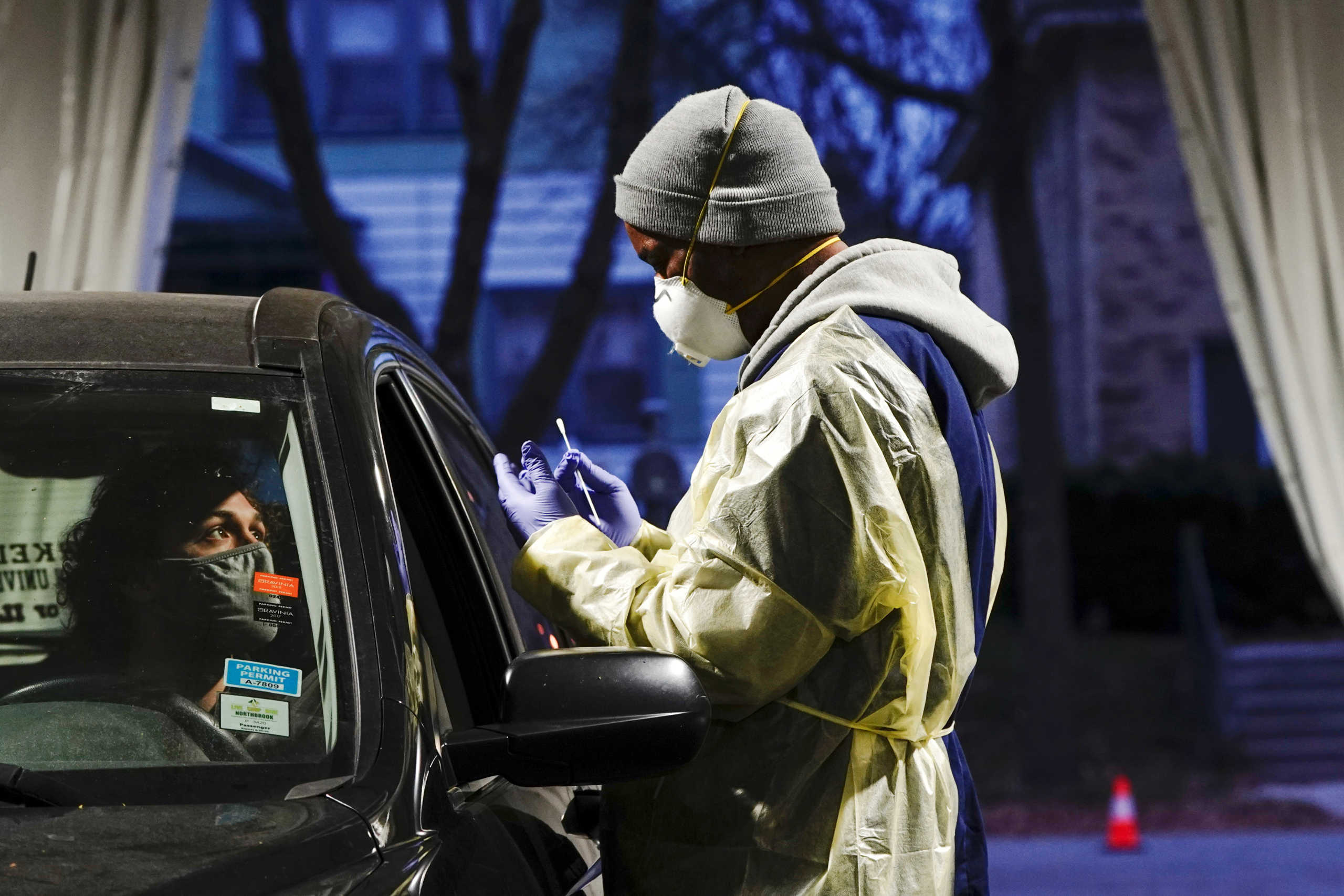FILE PHOTO: Certified nursing assistant (CNA) Jermaine LeFlore prepares to take a patient's nasal swab at a drive-thru testing site outside the Southside Health Center as the coronavirus disease (COVID-19) outbreak continues in Milwaukee, Wisconsin, U.S., October 21, 2020. REUTERS