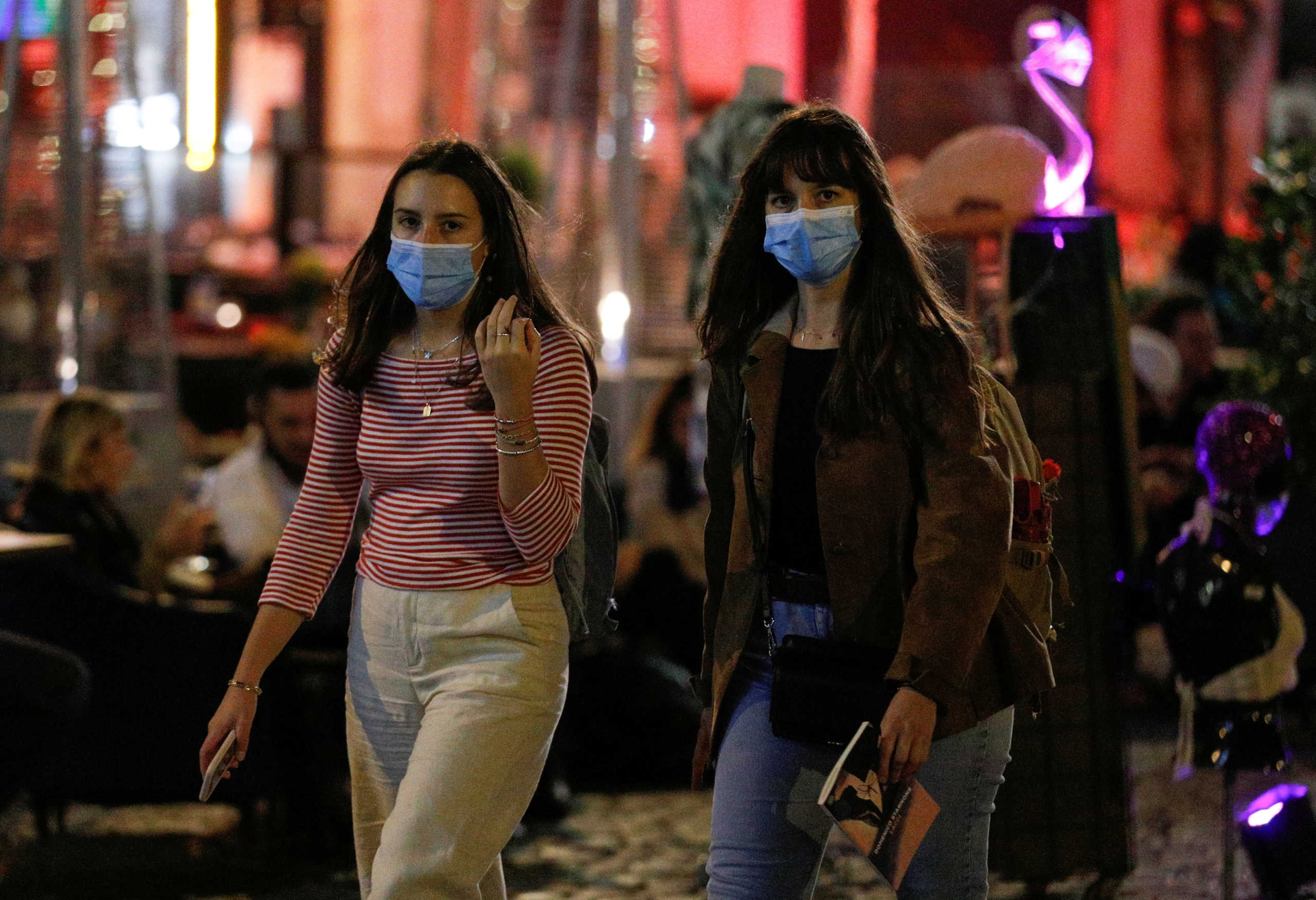 Women wearing protective face masks walk as local authorities in the Italian capital Rome order face coverings to be worn at all times out of doors in an effort to counter rising coronavirus disease (COVID-19) infections, in Rome, Italy. October 6, 2020. REUTERS