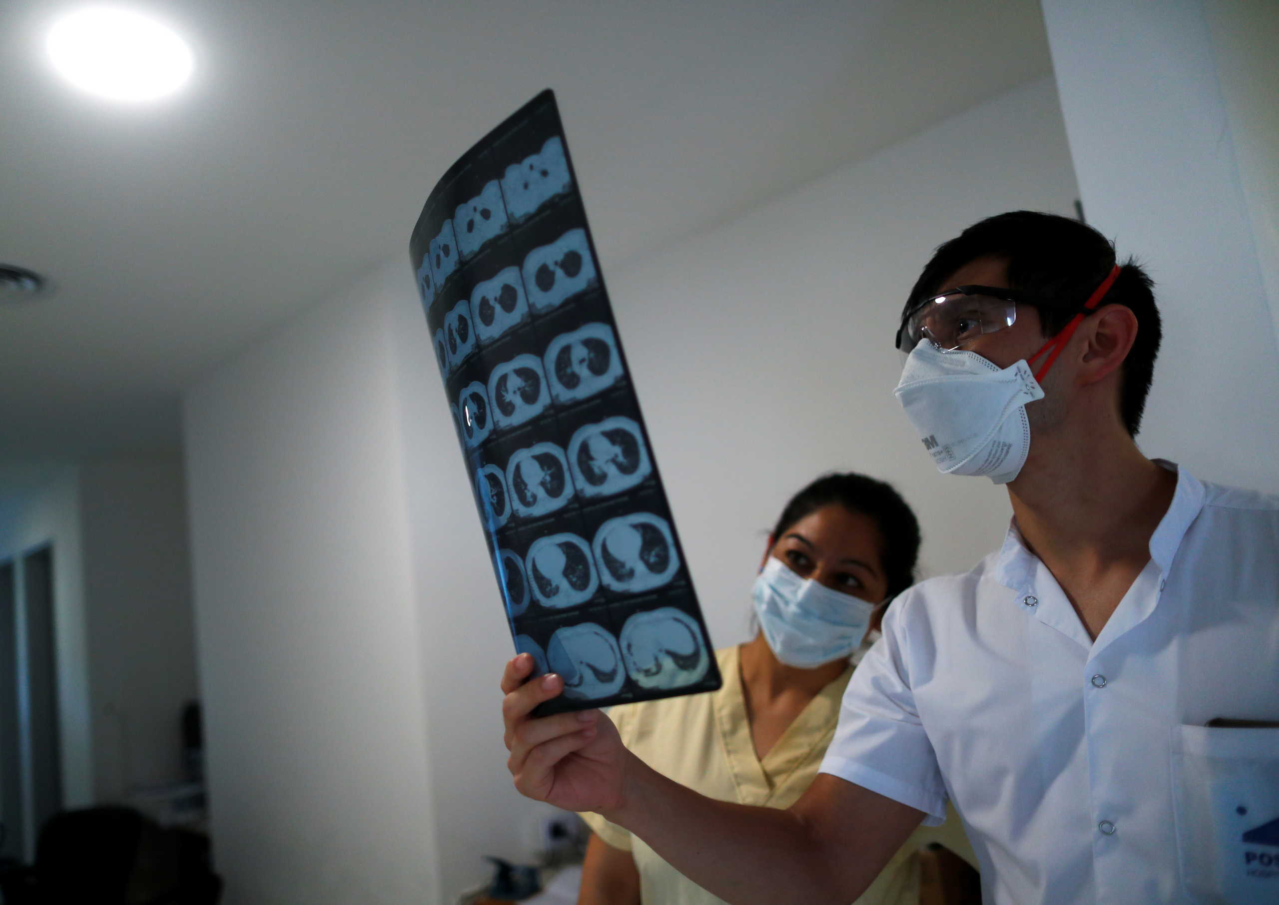 Doctor Cynthia Gimenez and Kinesiologist Jose Garcia check a radiography, as the spread of the coronavirus disease (COVID-19) continues, on the outskirts of Buenos Aires, Argentina October 16, 2020. Picture taken October 16, 2020. REUTERS