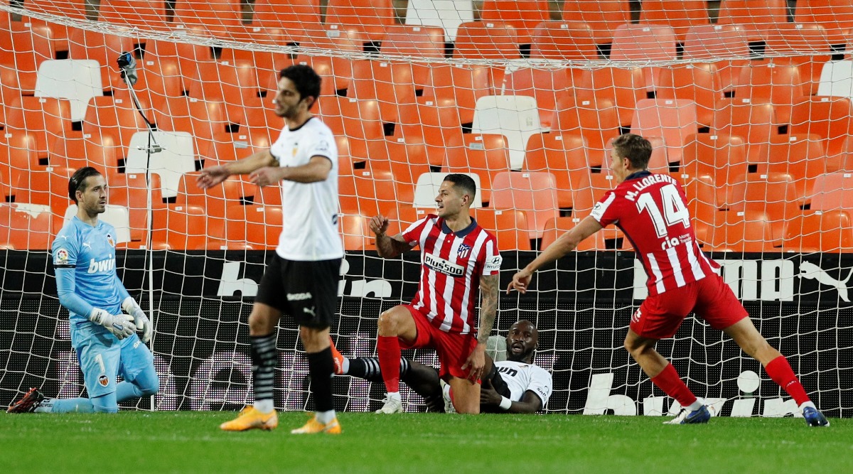 Soccer Football - La Liga Santander - Valencia v Atletico Madrid - Mestalla, Valencia, Spain - November 28, 2020 Atletico Madrid's Vitolo and Marcos Llorente celebrate their first goal as Valencia's Jaume Domenech and teammates look dejected REUTERS